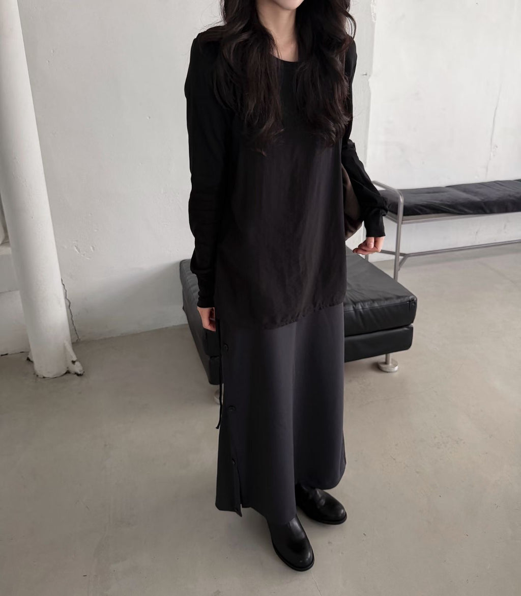 Front view of a charcoal skirt with gathered side styling and beige boots.