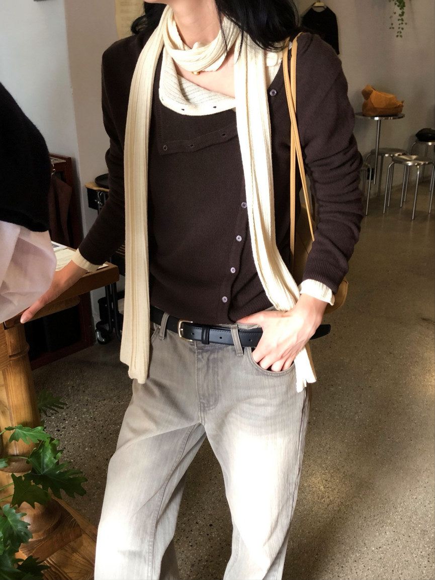 Black asymmetric button knit cardigan layered over a white shirt