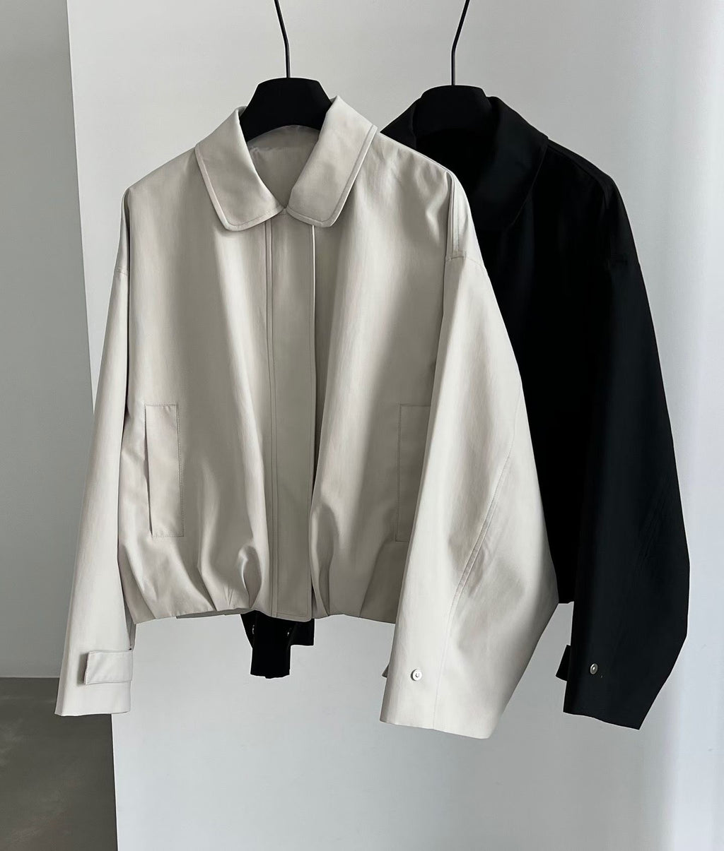 Ivory and black Stayhere collared blouson jackets on hangers showing front pockets and cuff tabs.
