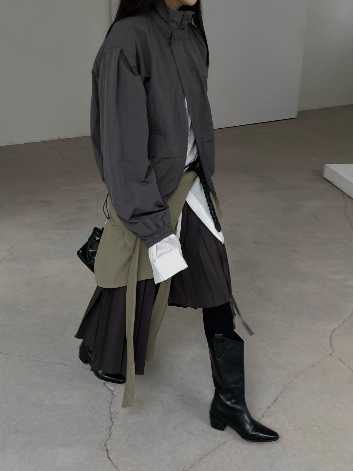 Side view of charcoal high-neck jacket with elasticated cuffs