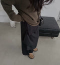 Mirror view of a charcoal maxi skirt in a straight silhouette styled with a black top.
