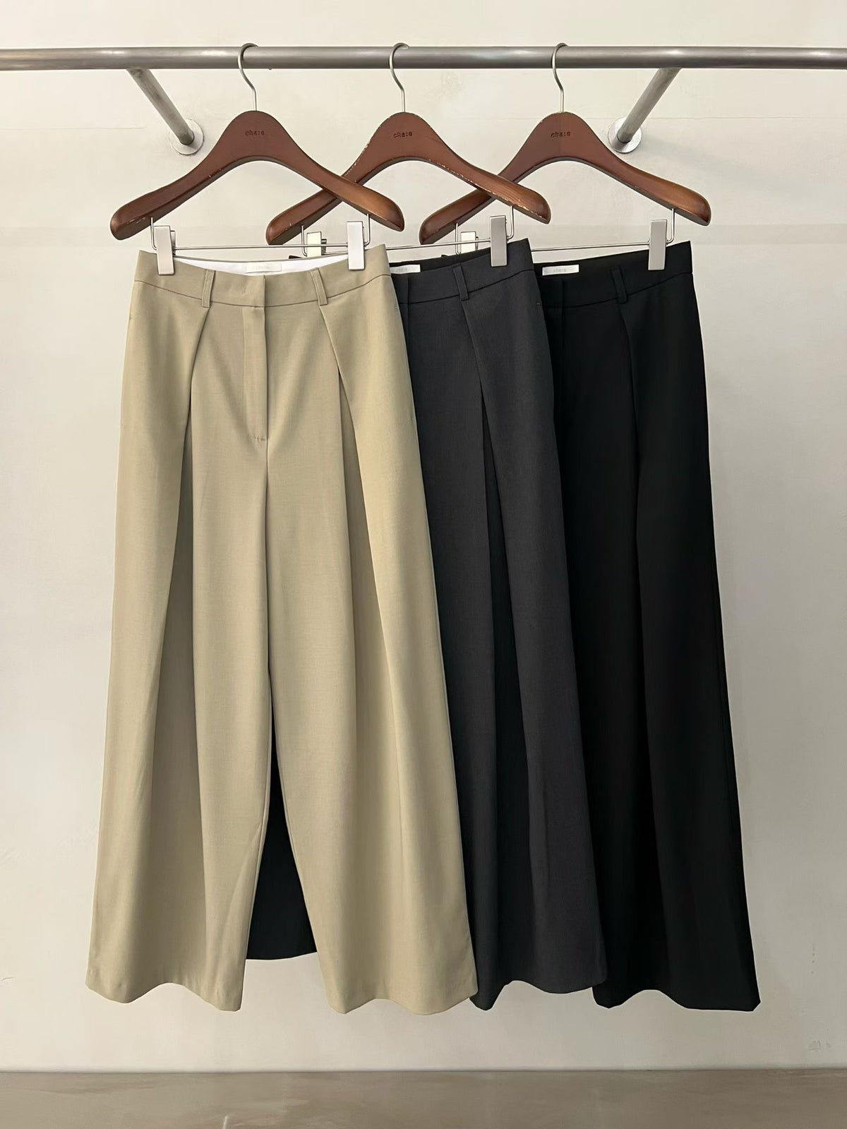 Front view of charcoal wide leg pants showing the front pleats and full-length legs.