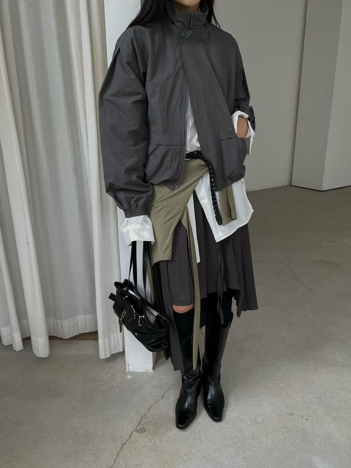 Charcoal long-sleeve high-neck jacket styled over a white shirt, full outfit