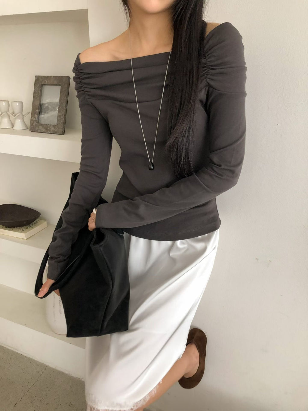 Black, charcoal and grey beige Dino ruched off-shoulder tops on white hangers.
