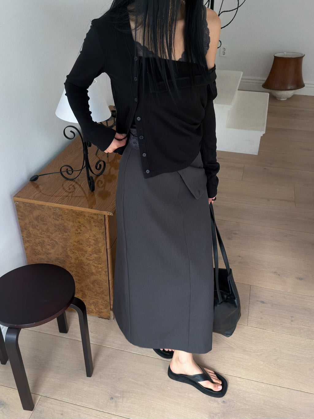 Angled front view of a charcoal cardigan showing long sleeves and folds across the front.