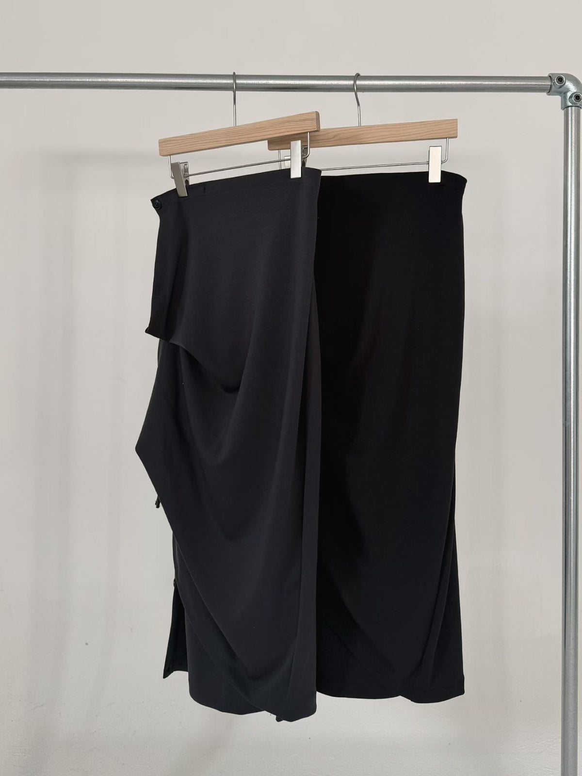 Charcoal and black Dino maxi skirts on hangers showing side buttons.