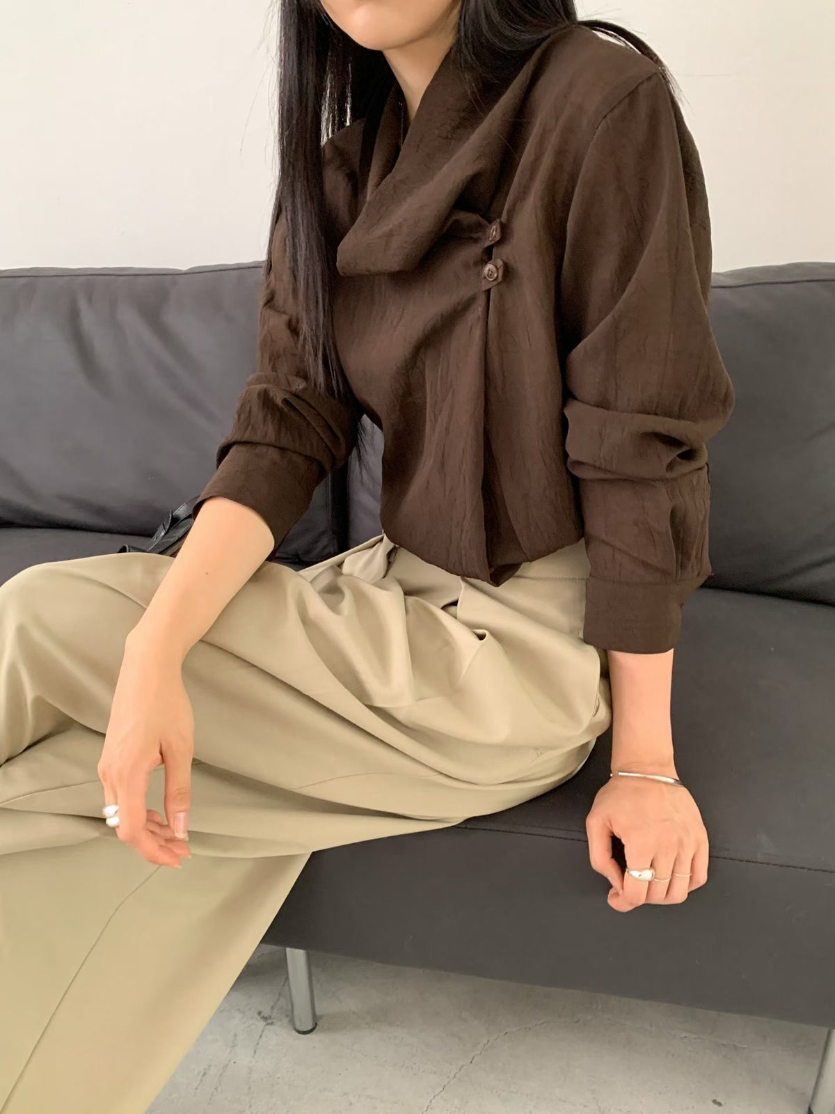 Beige wide leg pants showing front pleats, belt loops and side pockets.