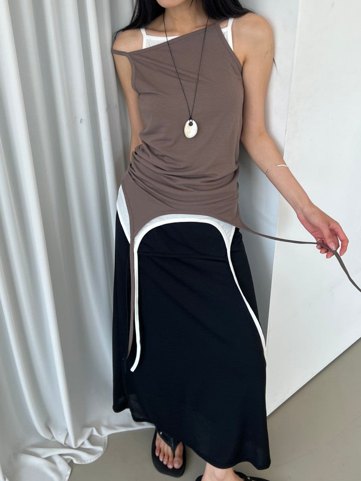 Askhaki square neck tank top with side tie strings in Black, styled on model front view with black mini skirt and leg warmers leaning on wall