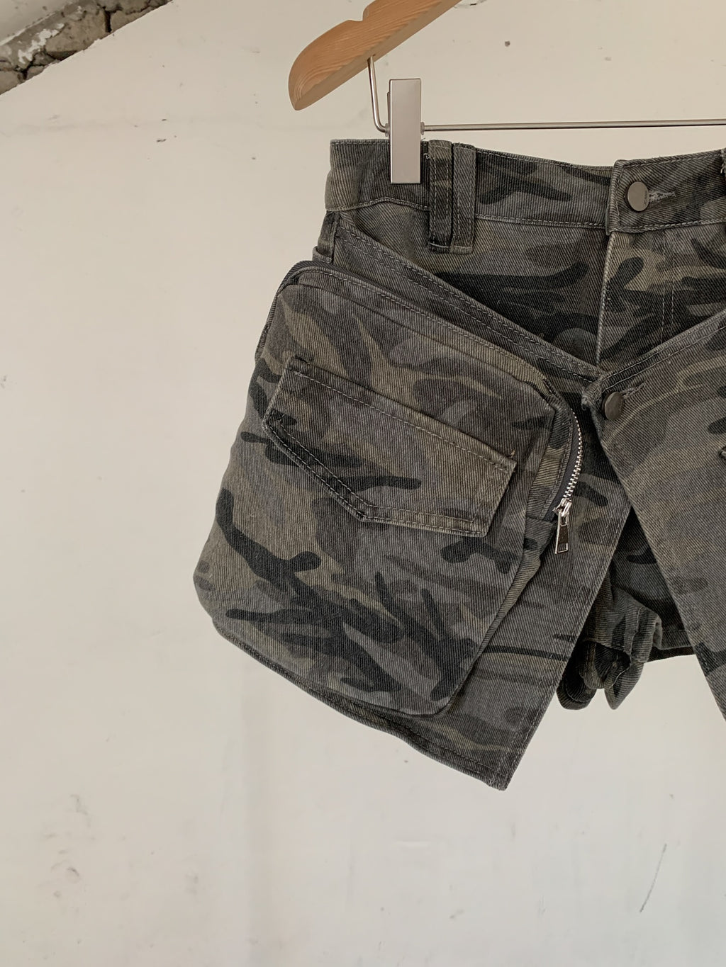 Vive L camo denim skort in Khaki, close-up of zip cargo pocket on hanger