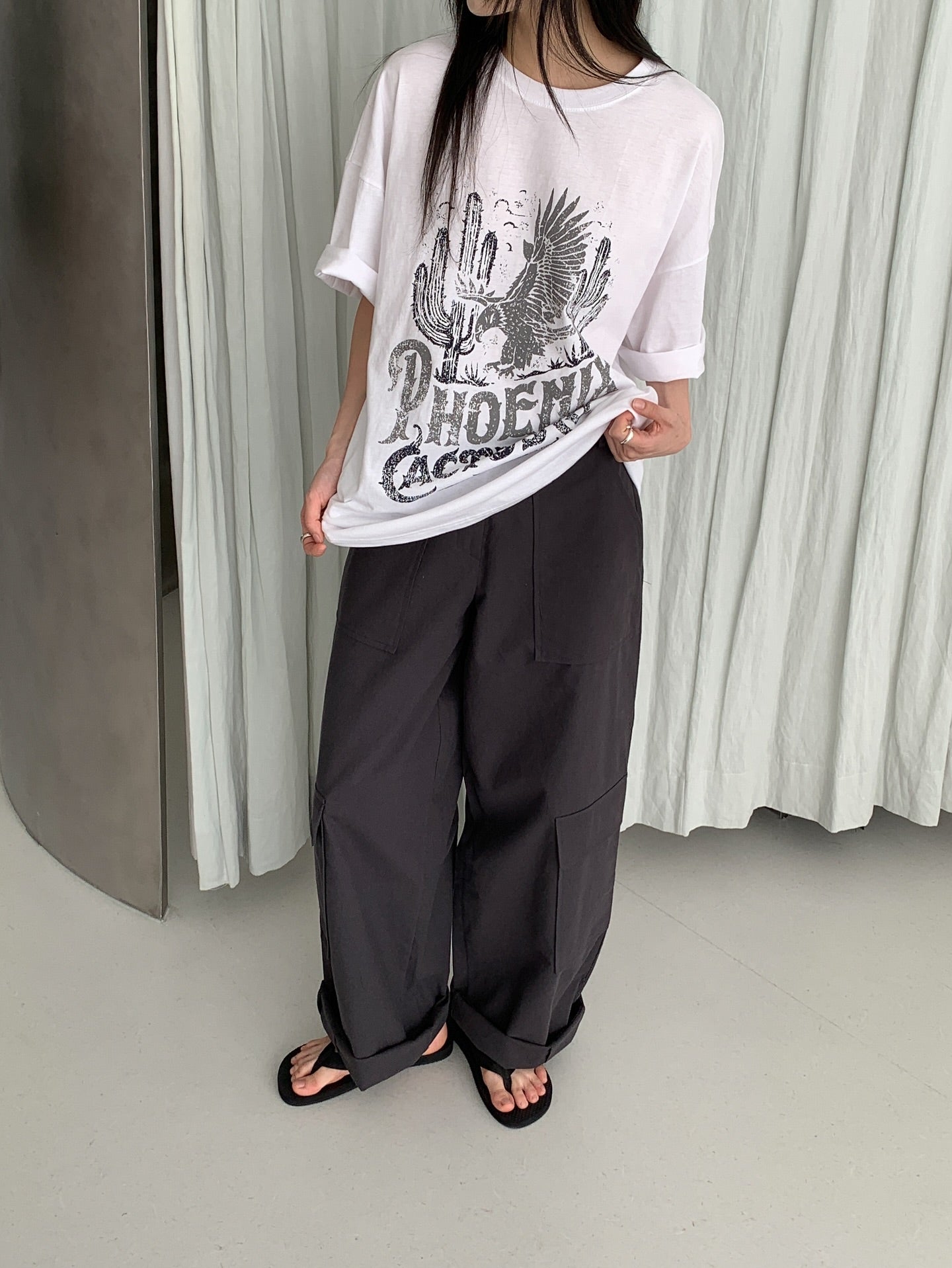 Vivel multi cargo pocket wide leg pants in Dark Beige, styled on model front view with black zip jacket and blue crop top and white tote bag
