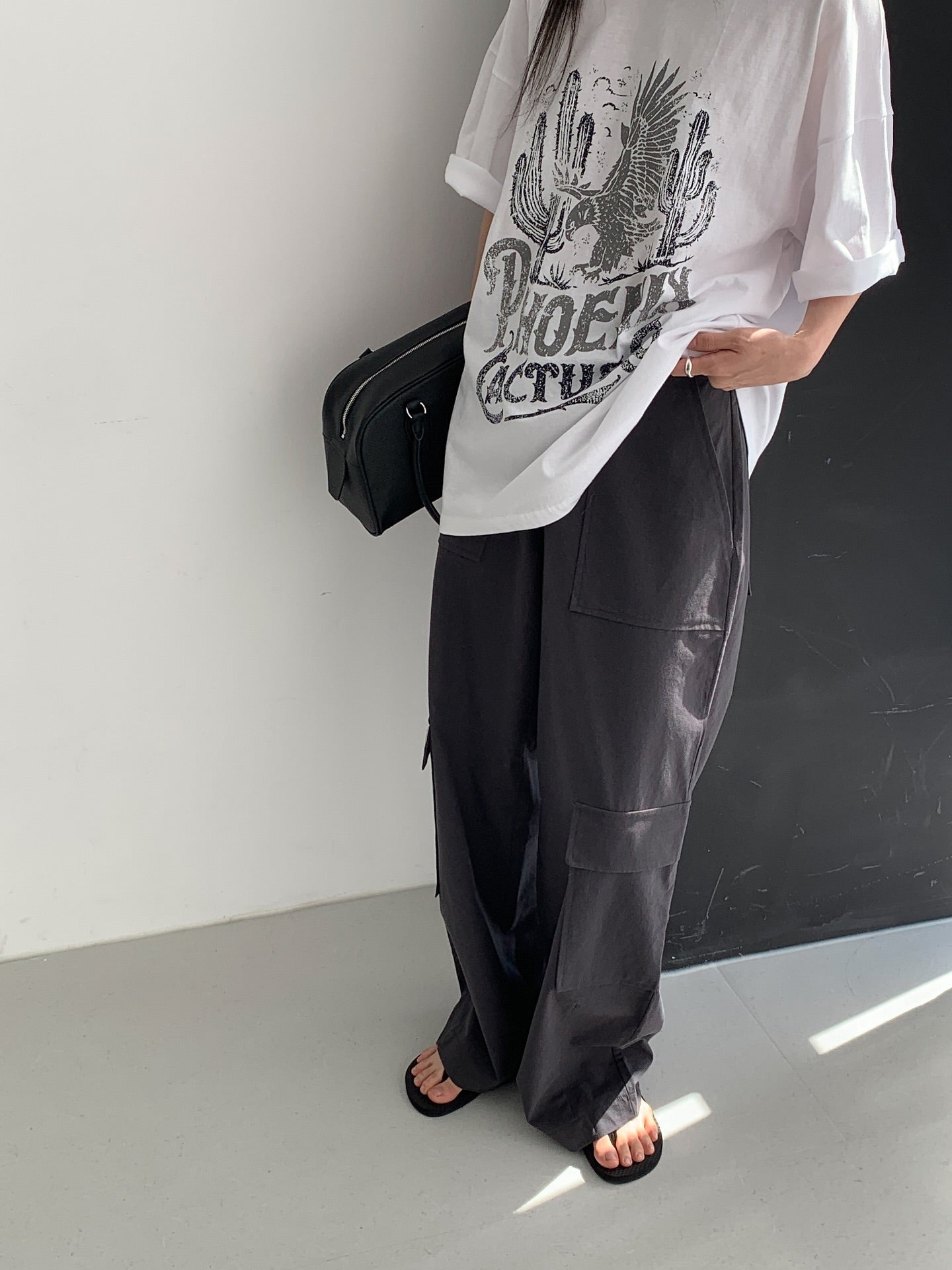 Vivel multi cargo pocket wide leg pants in Dark Beige, styled on model front view with white side-tie top and black mini bag