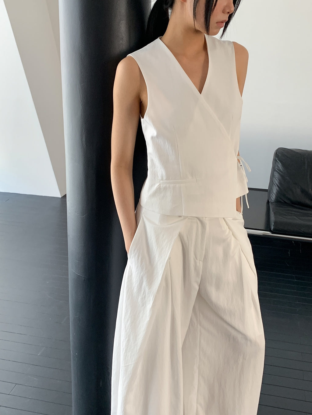 Vivel cross wrap vest in Navy, styled on model front view with navy wide leg pants full length standing by stairs