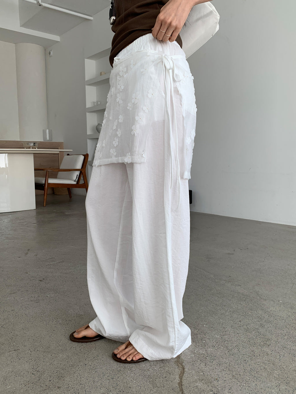 Merrymore floral overlay wrap layered wide leg pants in Black and White, two colorways on hanger against white wall