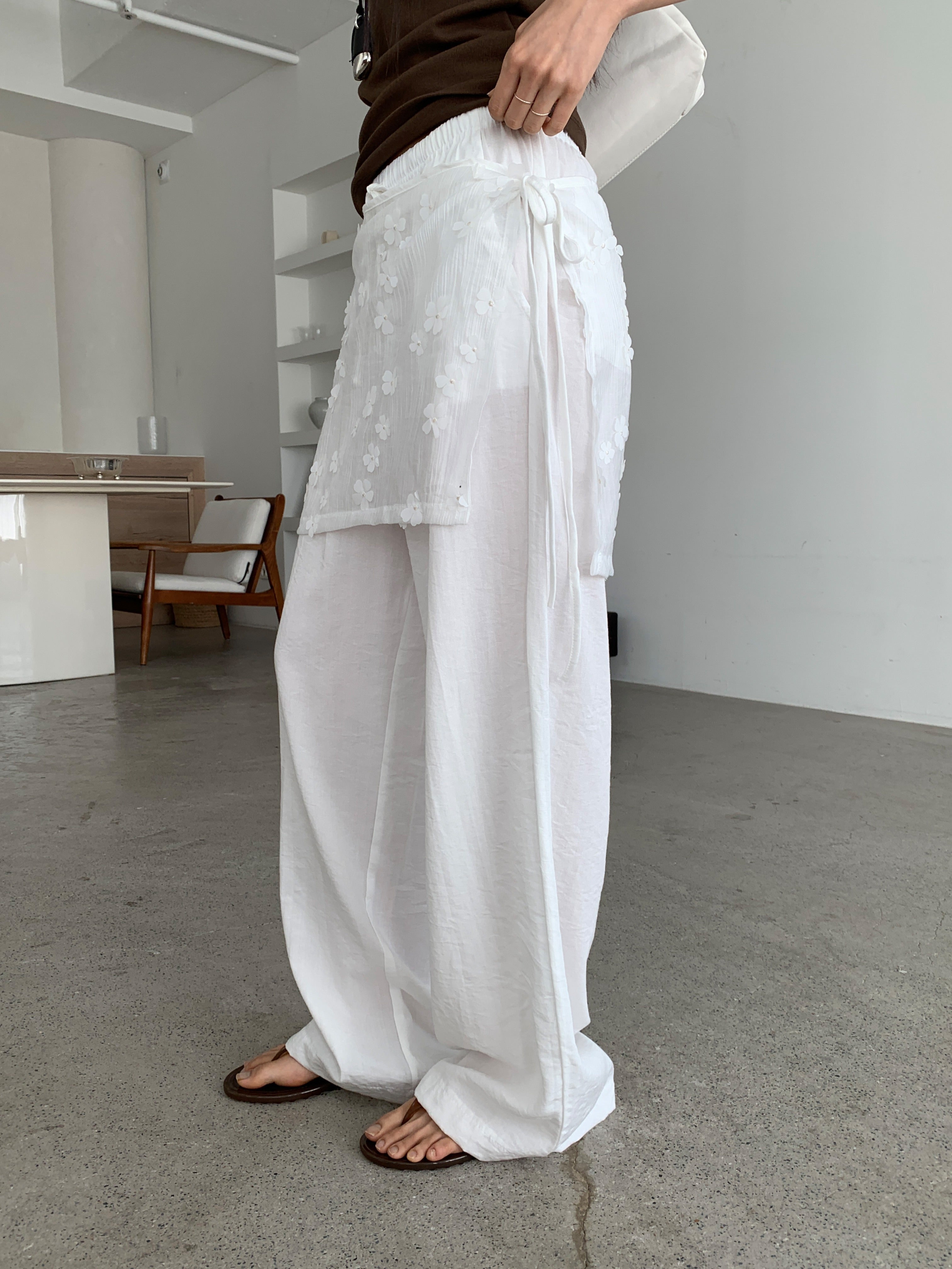 Merrymore floral overlay wrap layered wide leg pants in Black and White, two colorways on hanger against white wall