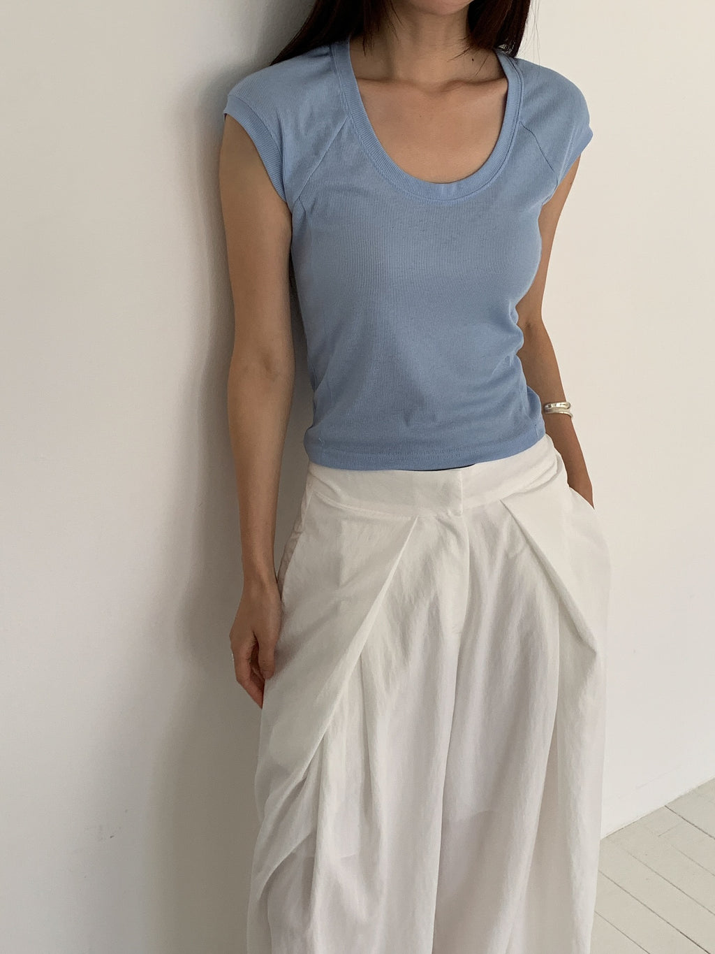 Vivel high waist deep pleat wide leg pants in White, styled on model front view close-up pleat detail with blue ribbed crop top