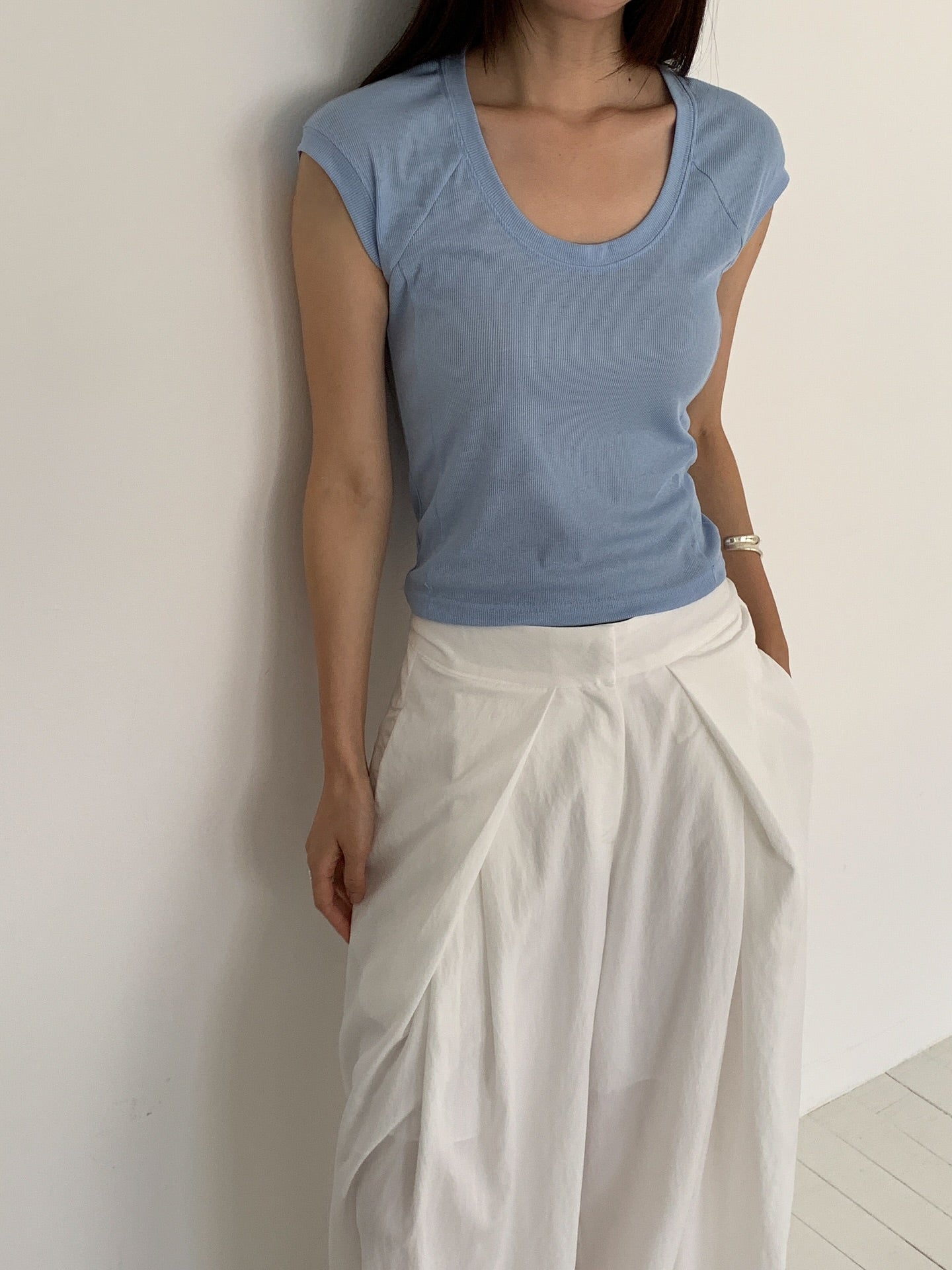 Vivel high waist deep pleat wide leg pants in White, styled on model front view close-up pleat detail with blue ribbed crop top
