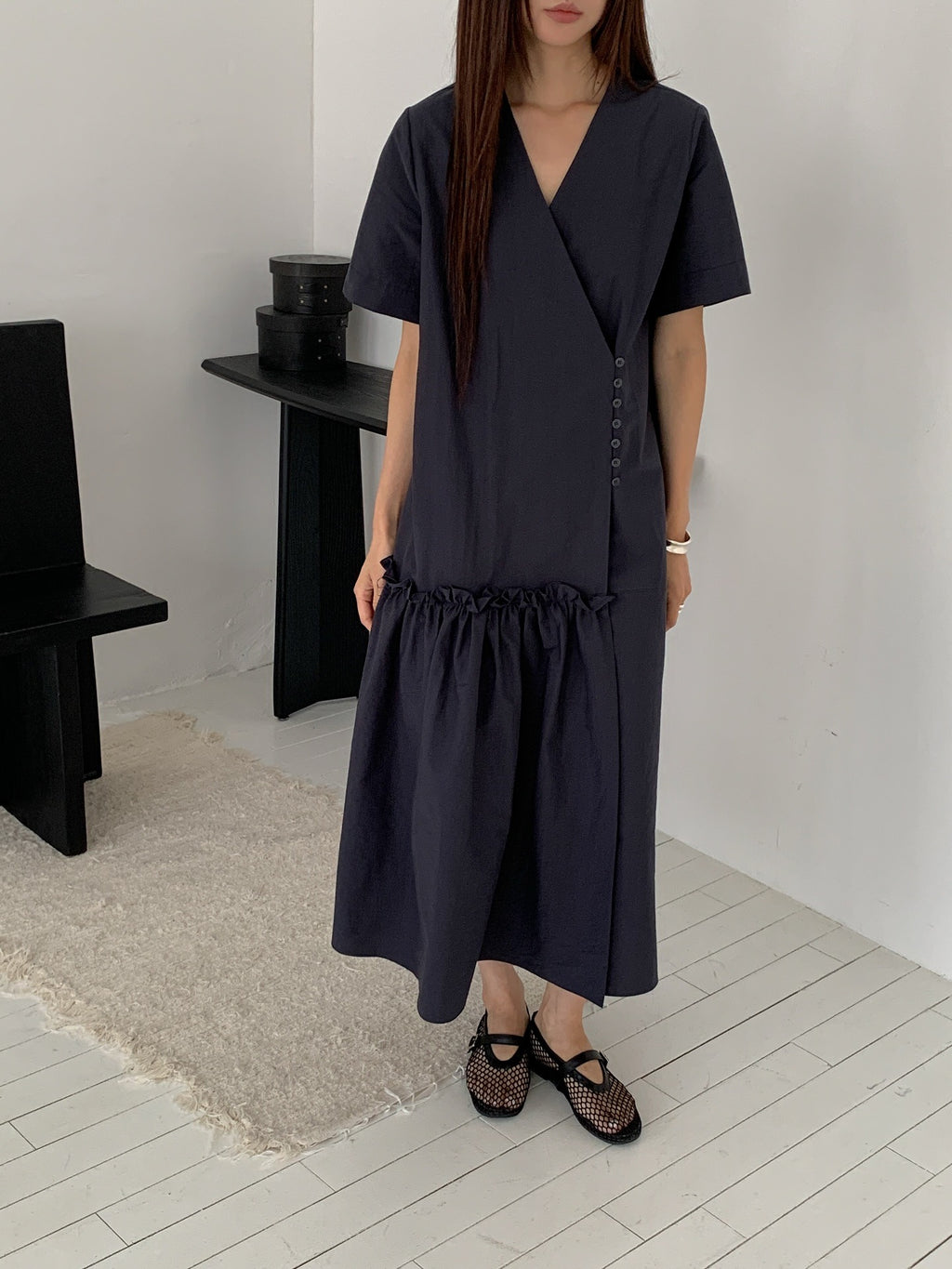 Vivel wrap shirring maxi dress in Charcoal, styled on model front view full length leaning on white wall