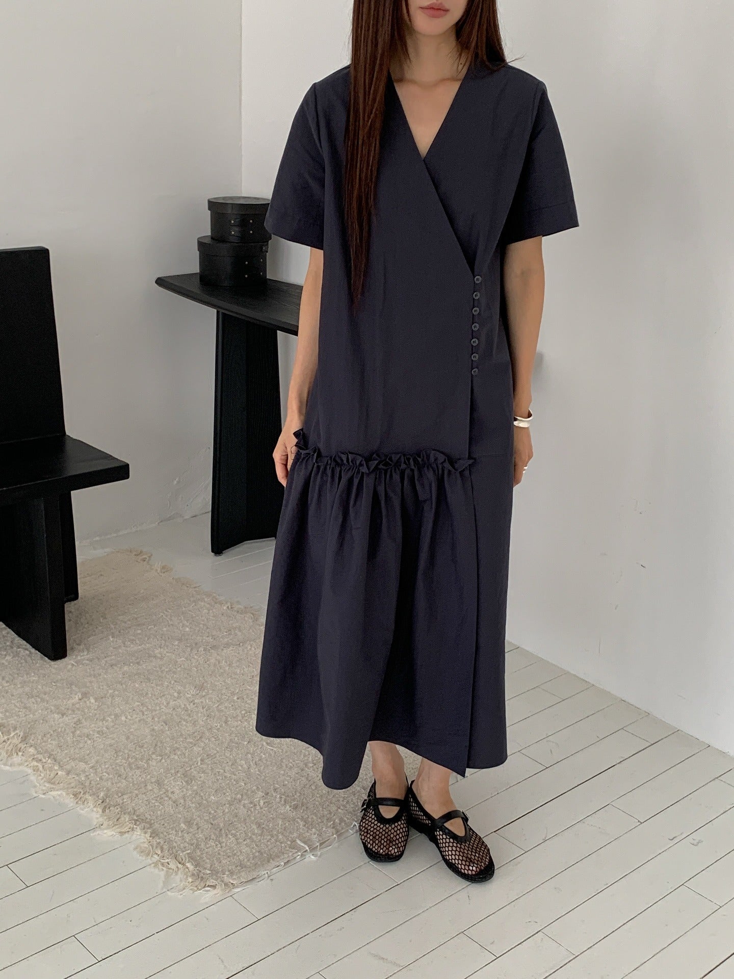 Vivel wrap shirring maxi dress in Charcoal, styled on model front view full length leaning on white wall