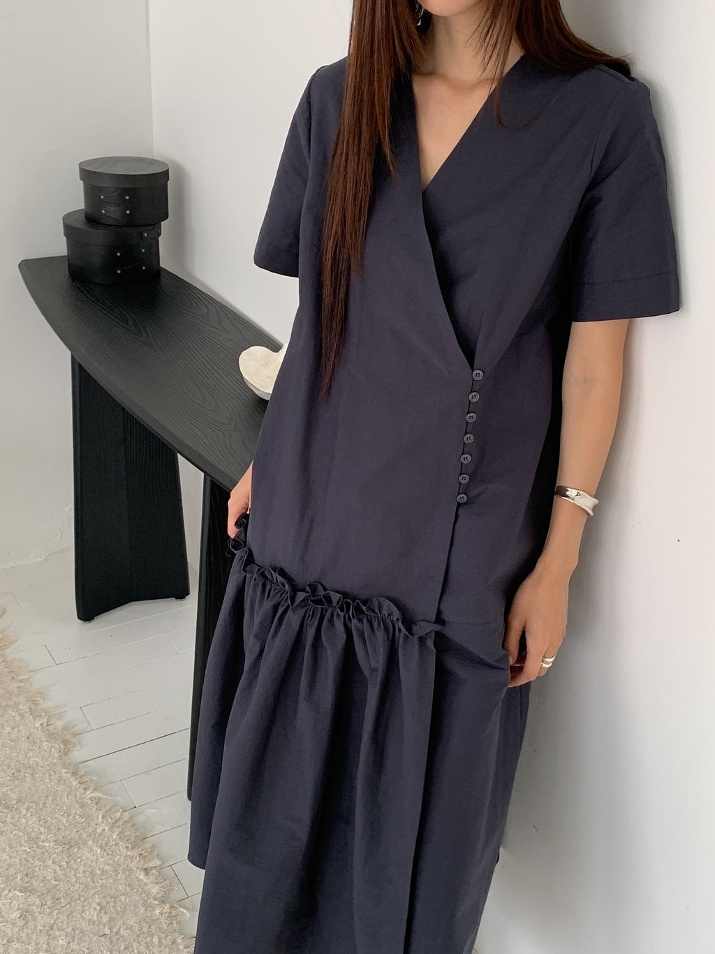 Vivel wrap shirring maxi dress in Charcoal, styled on model front view close-up V-neck crossover and button detail by black console