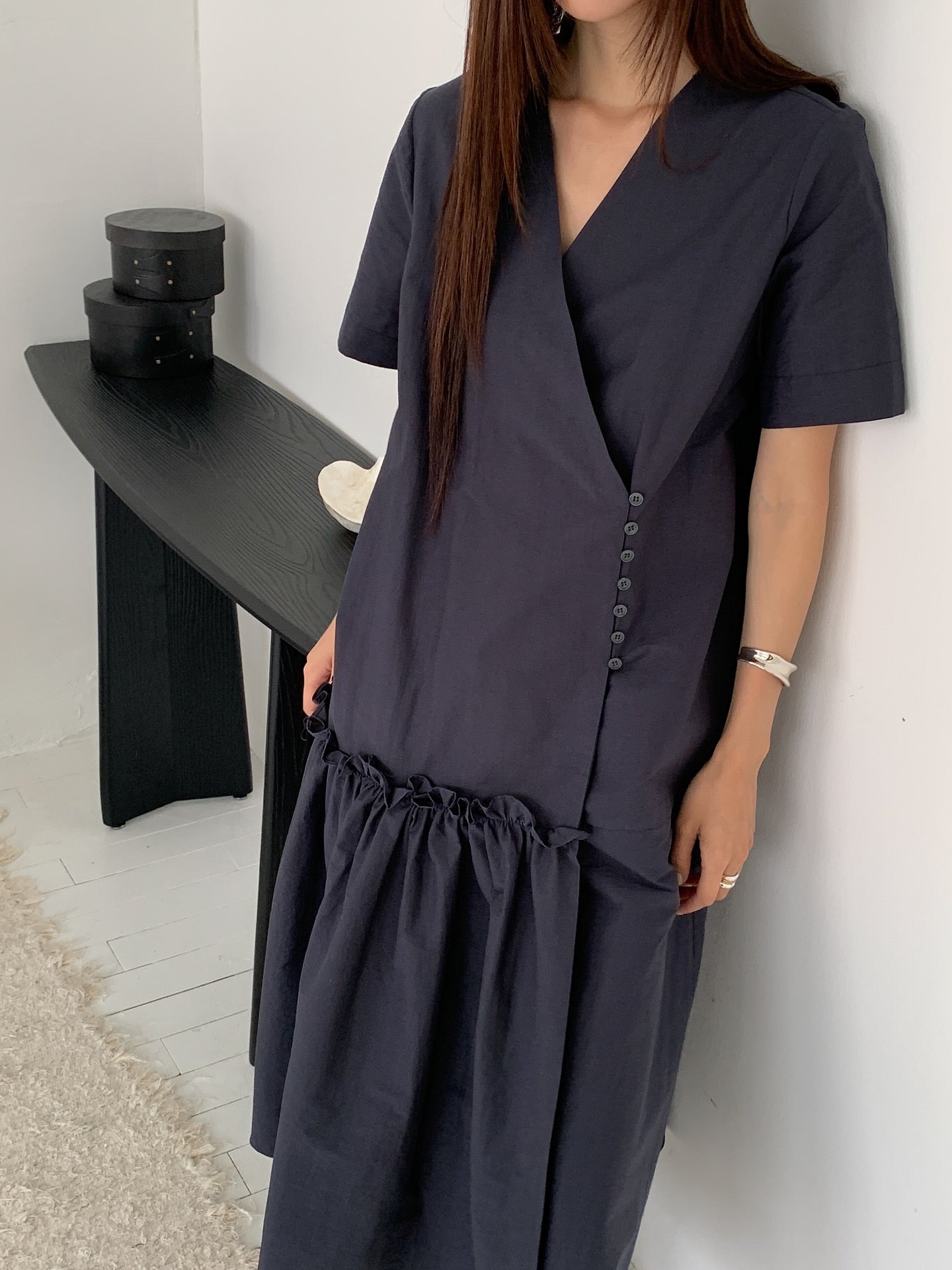 Vivel wrap shirring maxi dress in Charcoal, styled on model front view close-up V-neck crossover and button detail by black console