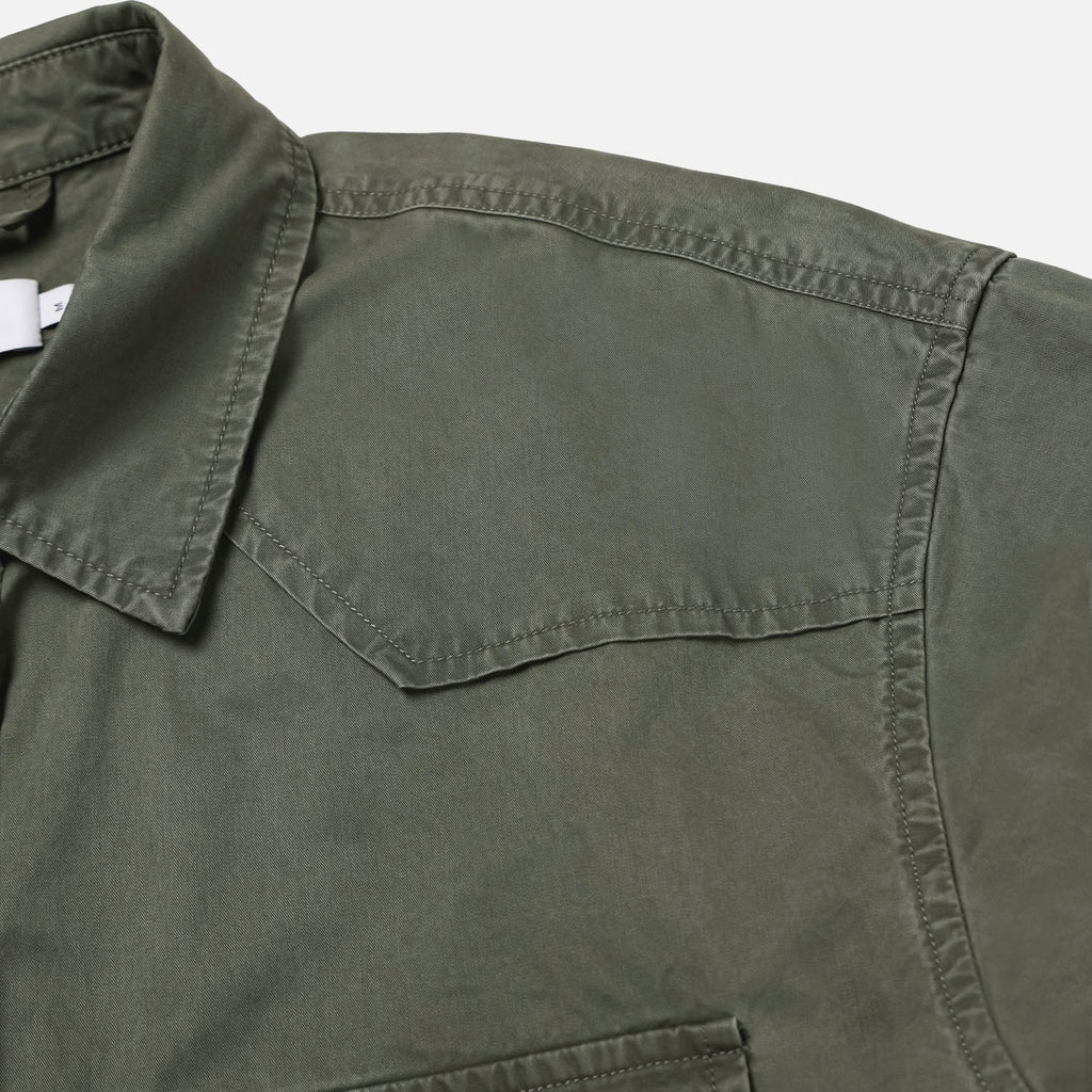 Curved hem and washed seam detail on a khaki cotton western shirt