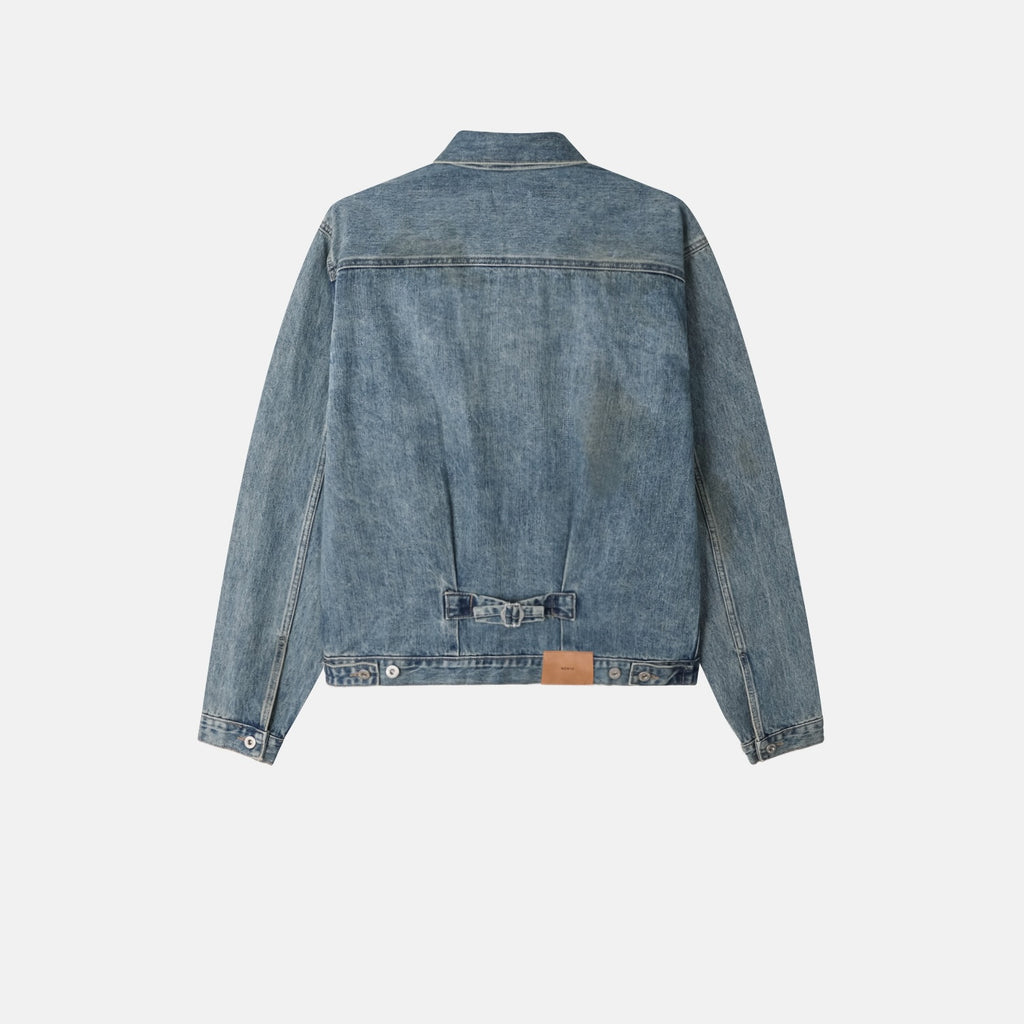 Collar, front yoke and metal button detail on a mid-blue denim jacket