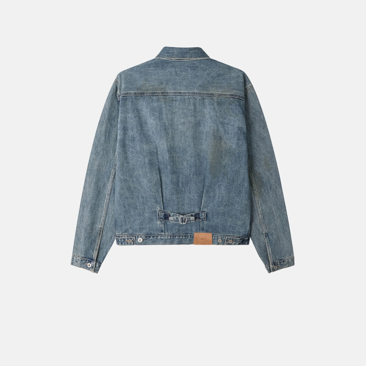 Collar, front yoke and metal button detail on a mid-blue denim jacket