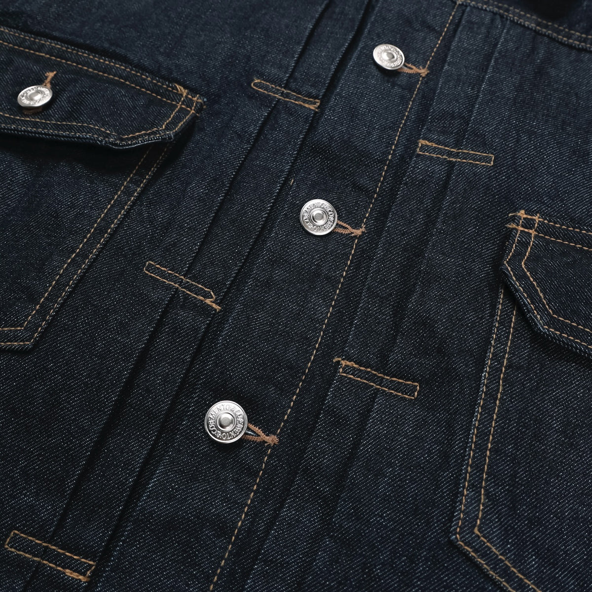 Pointed collar and front yoke detail on a raw indigo trucker jacket