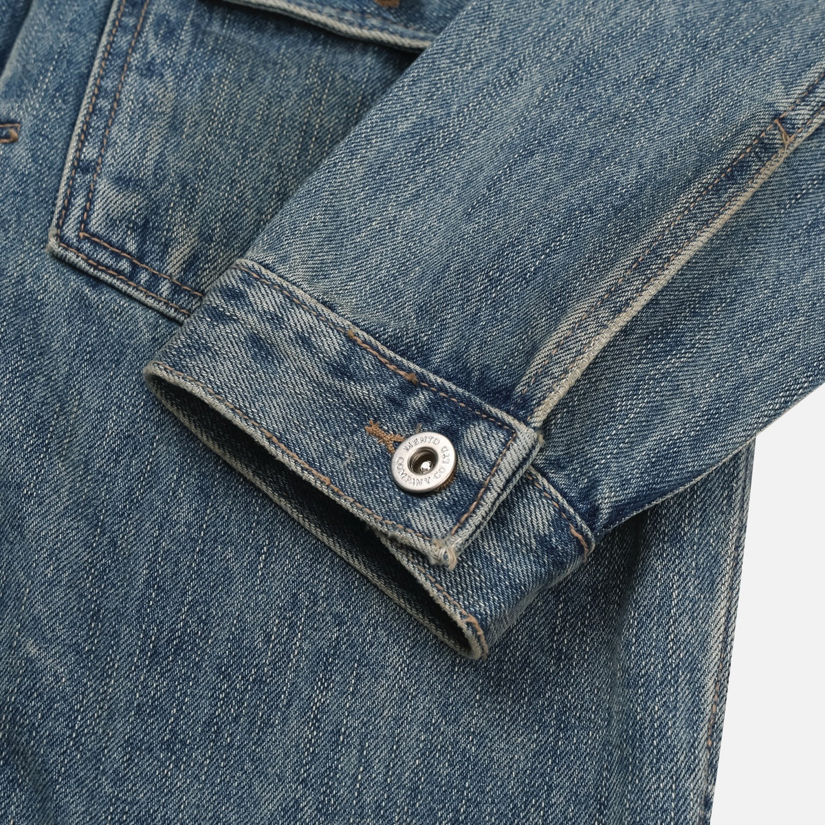 Back view of mid-blue men's denim jacket with adjustable waist tab