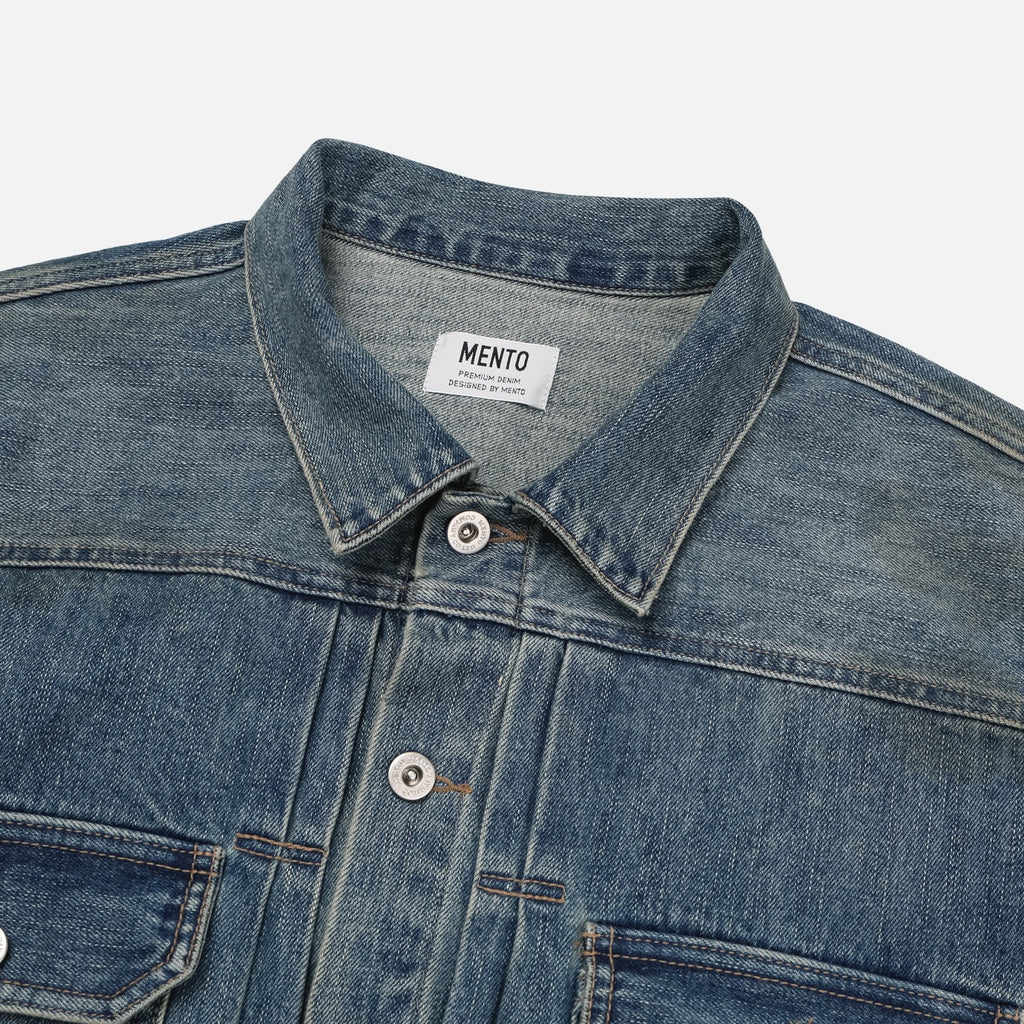 Adjustable back waist tab and Mento label on a mid-wash denim jacket