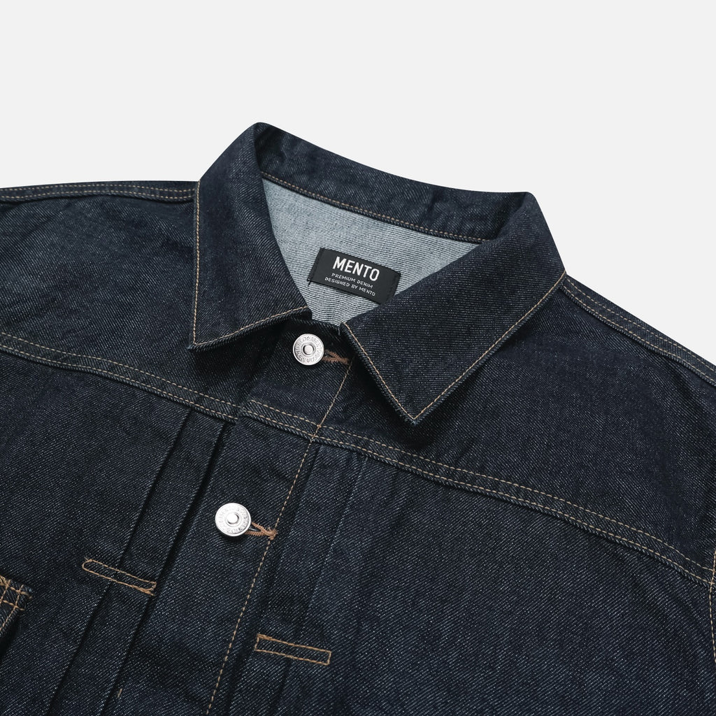 Back yoke and contrast stitching detail on a raw indigo denim jacket