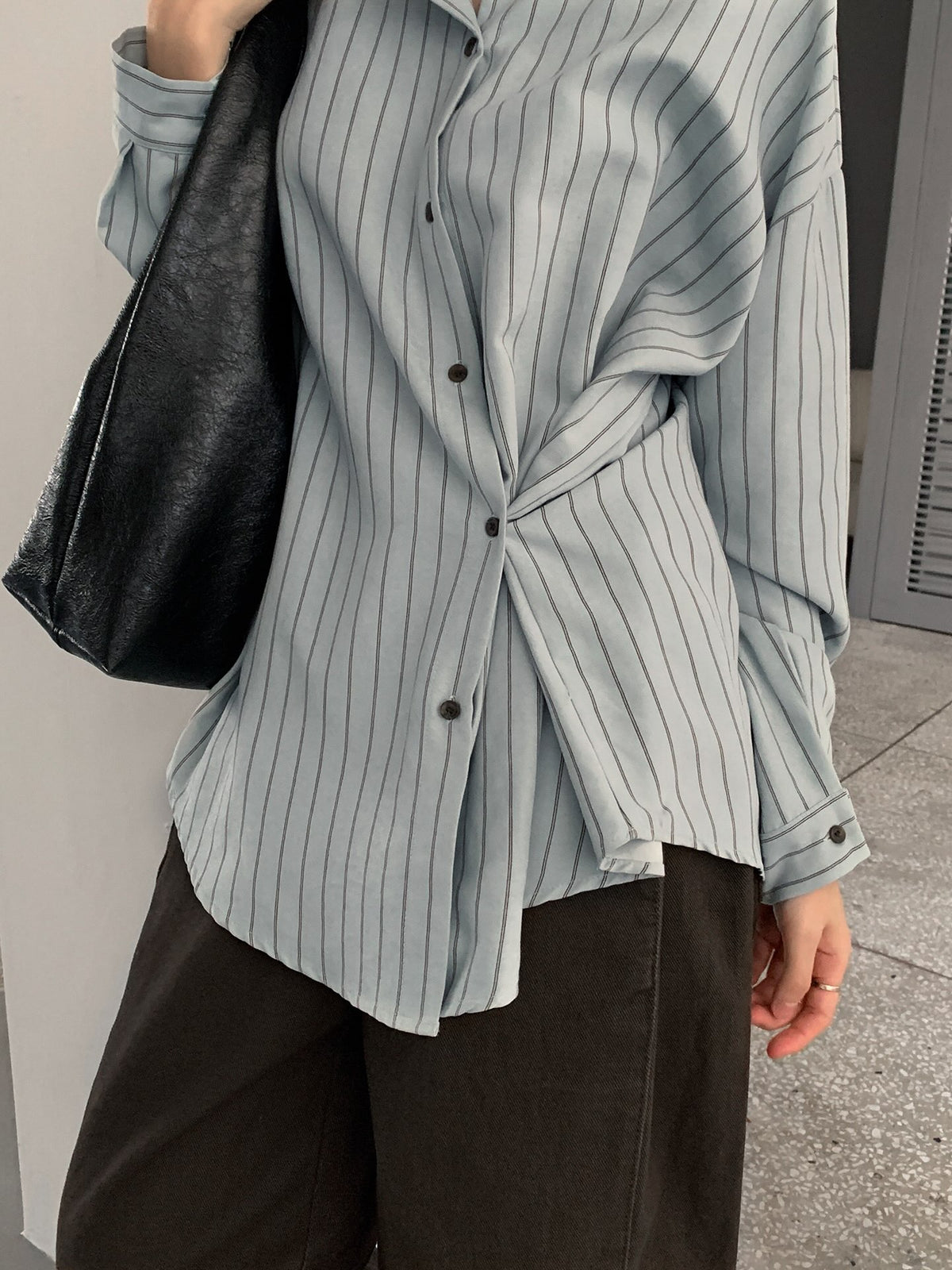 Full-length outfit with a sky blue striped shirt and dark trousers.