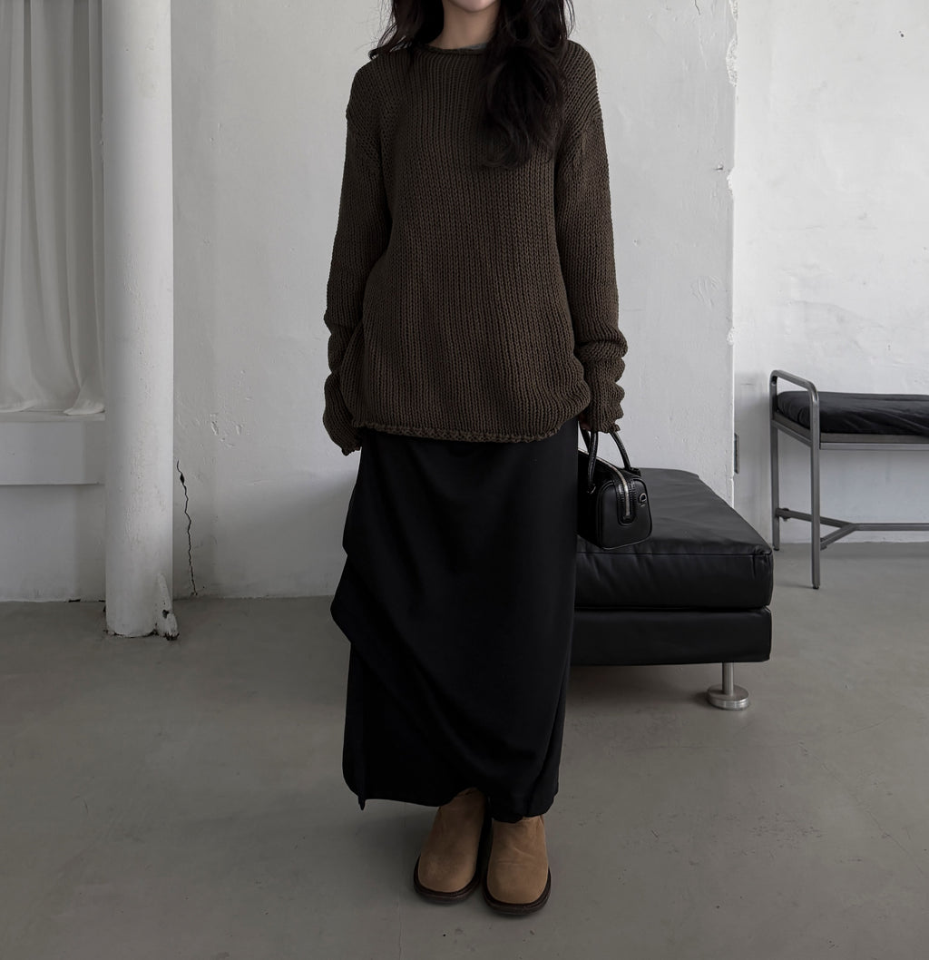 Close-up of the side button row on a charcoal maxi skirt styled with black boots.