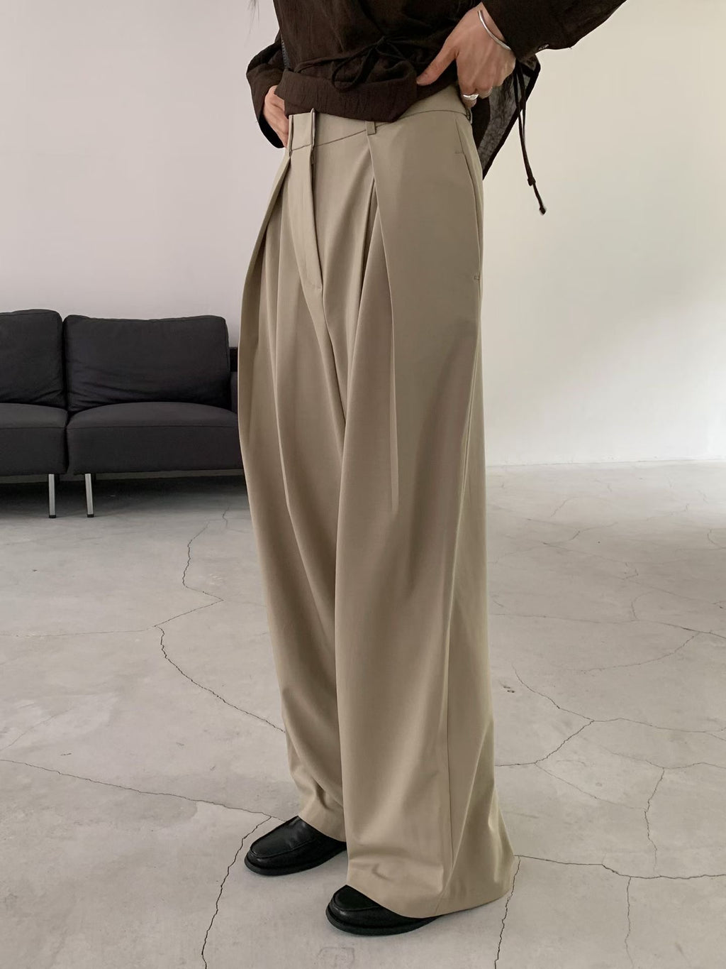Side view of charcoal wide leg pants with a hand in the side pocket.