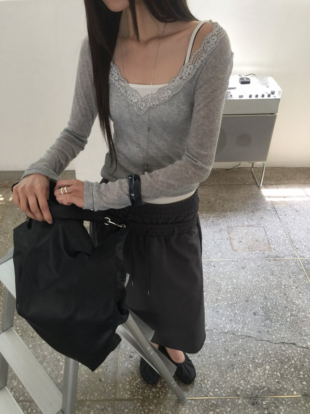 Nweol lace trim V-neck long sleeve top in Grey, styled on model front view with charcoal skirt close-up