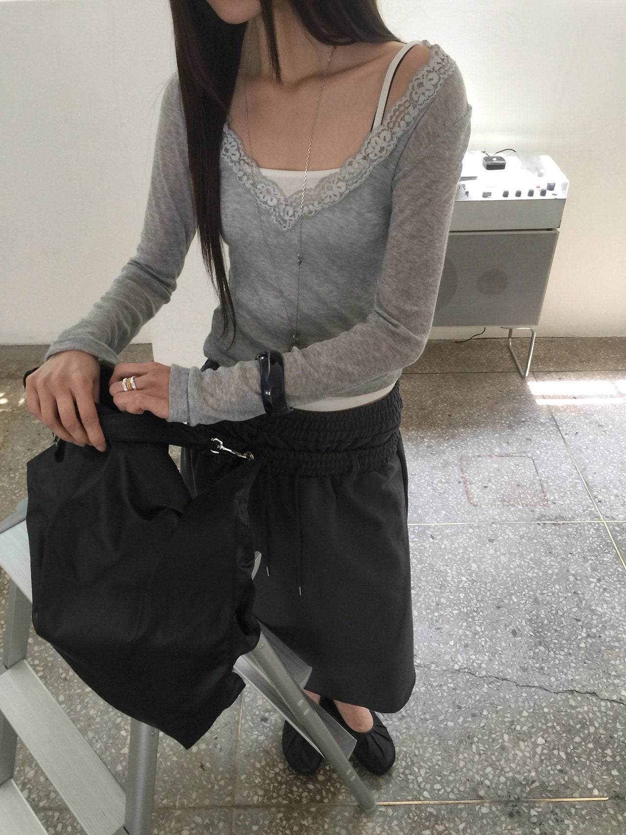 Nweol lace trim V-neck long sleeve top in Grey, styled on model front view with charcoal skirt close-up