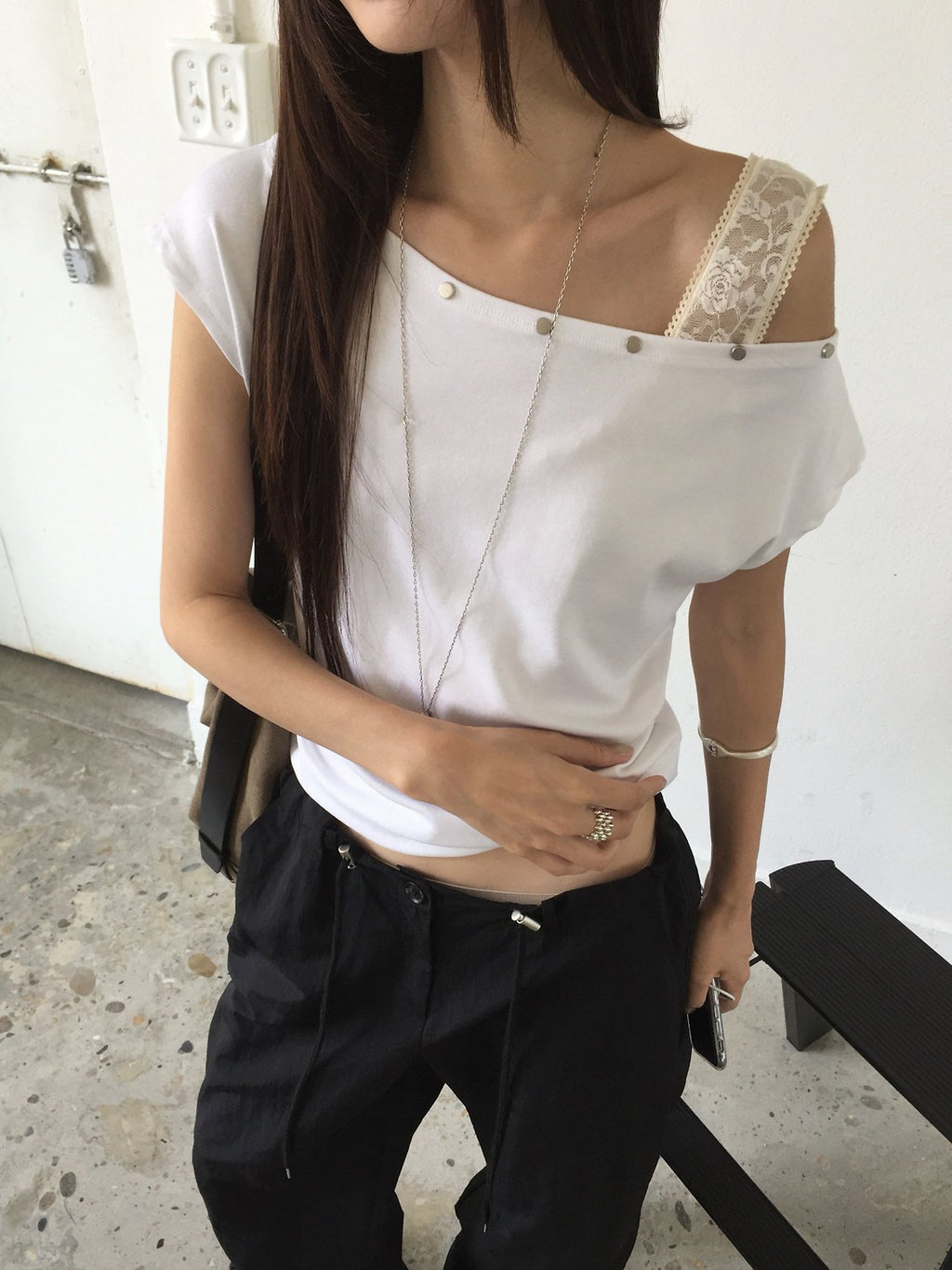 Nweol asymmetric one-shoulder top, three colorways flat lay — Ivory, Charcoal, Deep Blue
