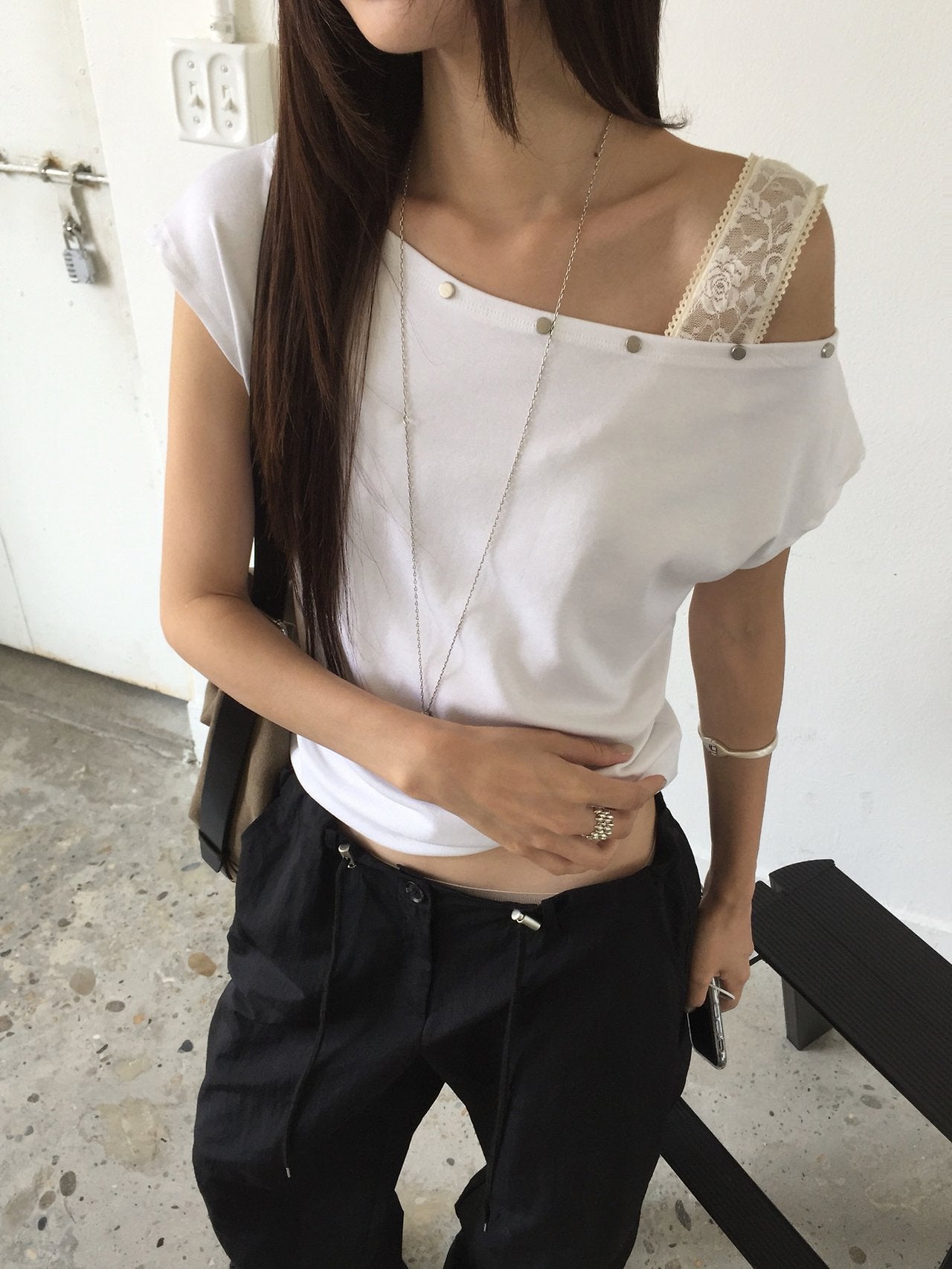 Nweol asymmetric one-shoulder top, three colorways flat lay — Ivory, Charcoal, Deep Blue