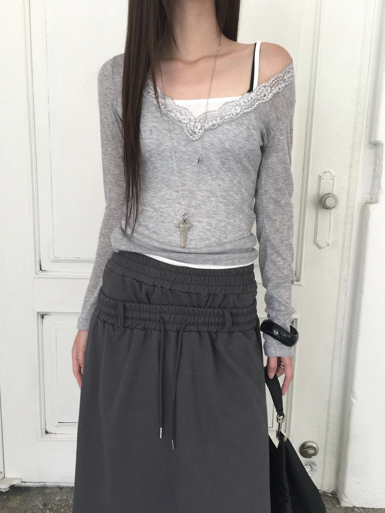 Nweol lace trim V-neck long sleeve top in Grey, styled on model front view with charcoal skirt full length