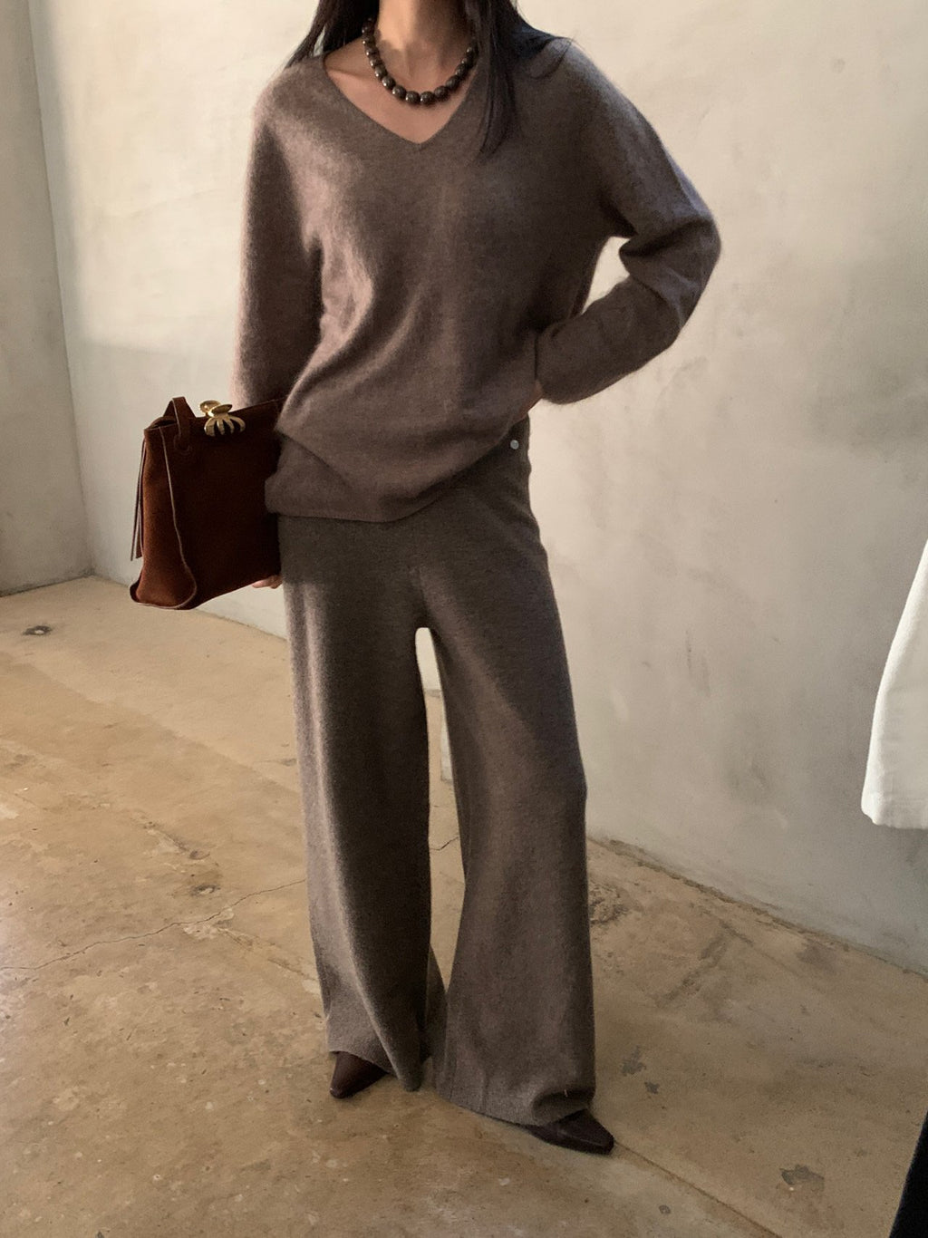 Side view of charcoal knit pants with one leg raised