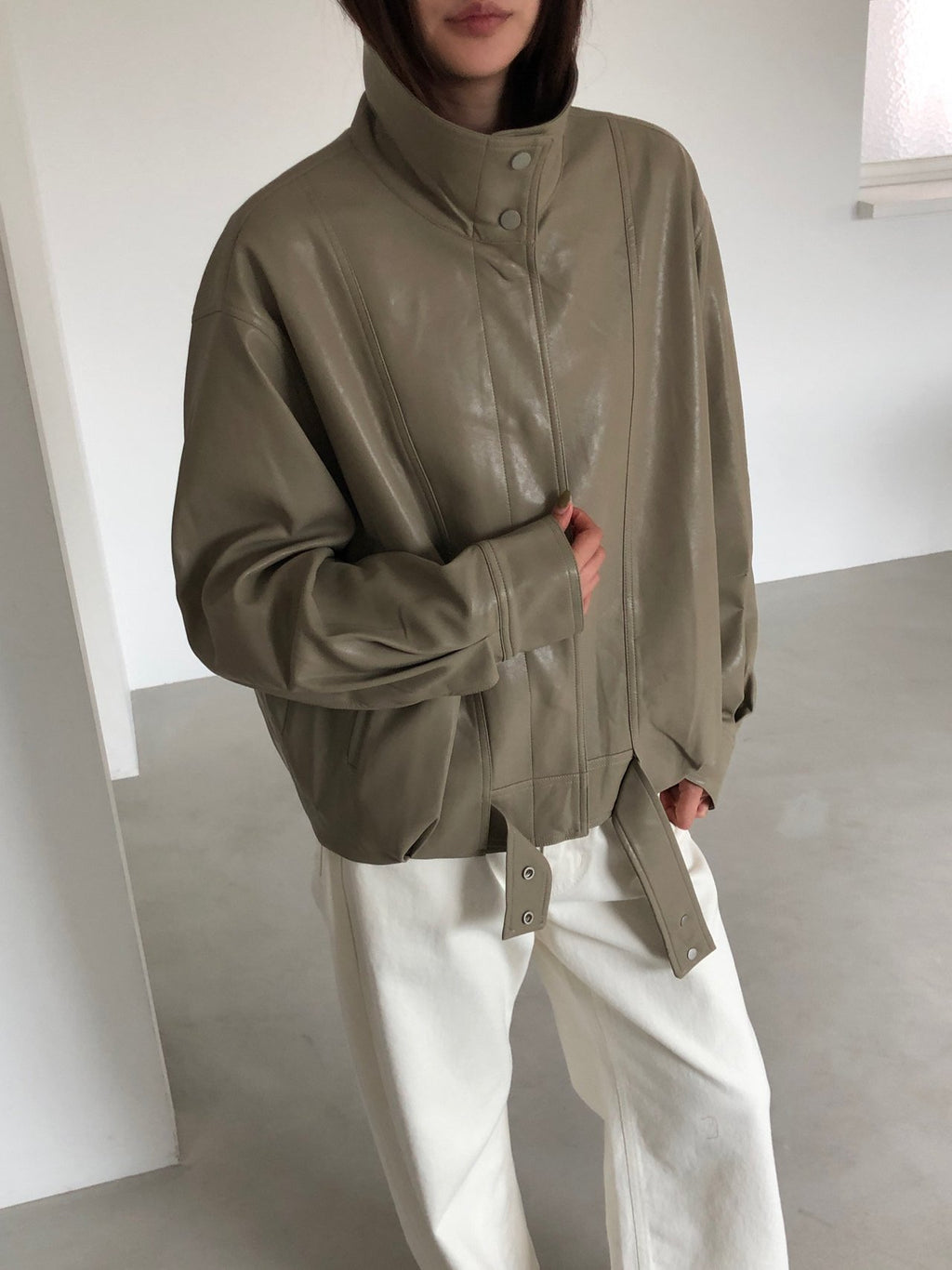 Back view of beige jacket with high collar and central back seam
