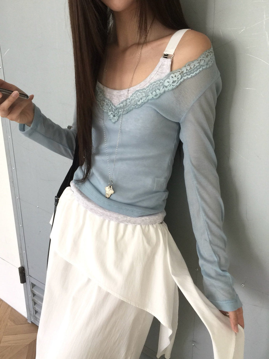 Nweol lace trim V-neck long sleeve top in Soft Blue, styled on model front view with white maxi skirt