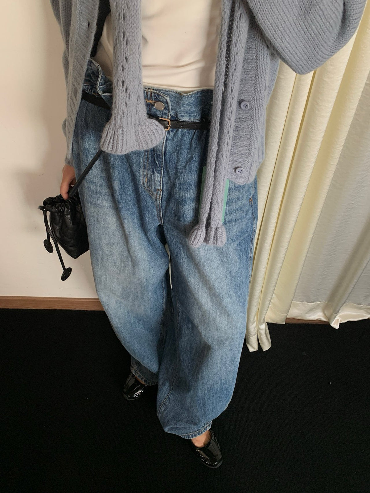 Blue wide-leg jeans and black belt styled with a grey cardigan