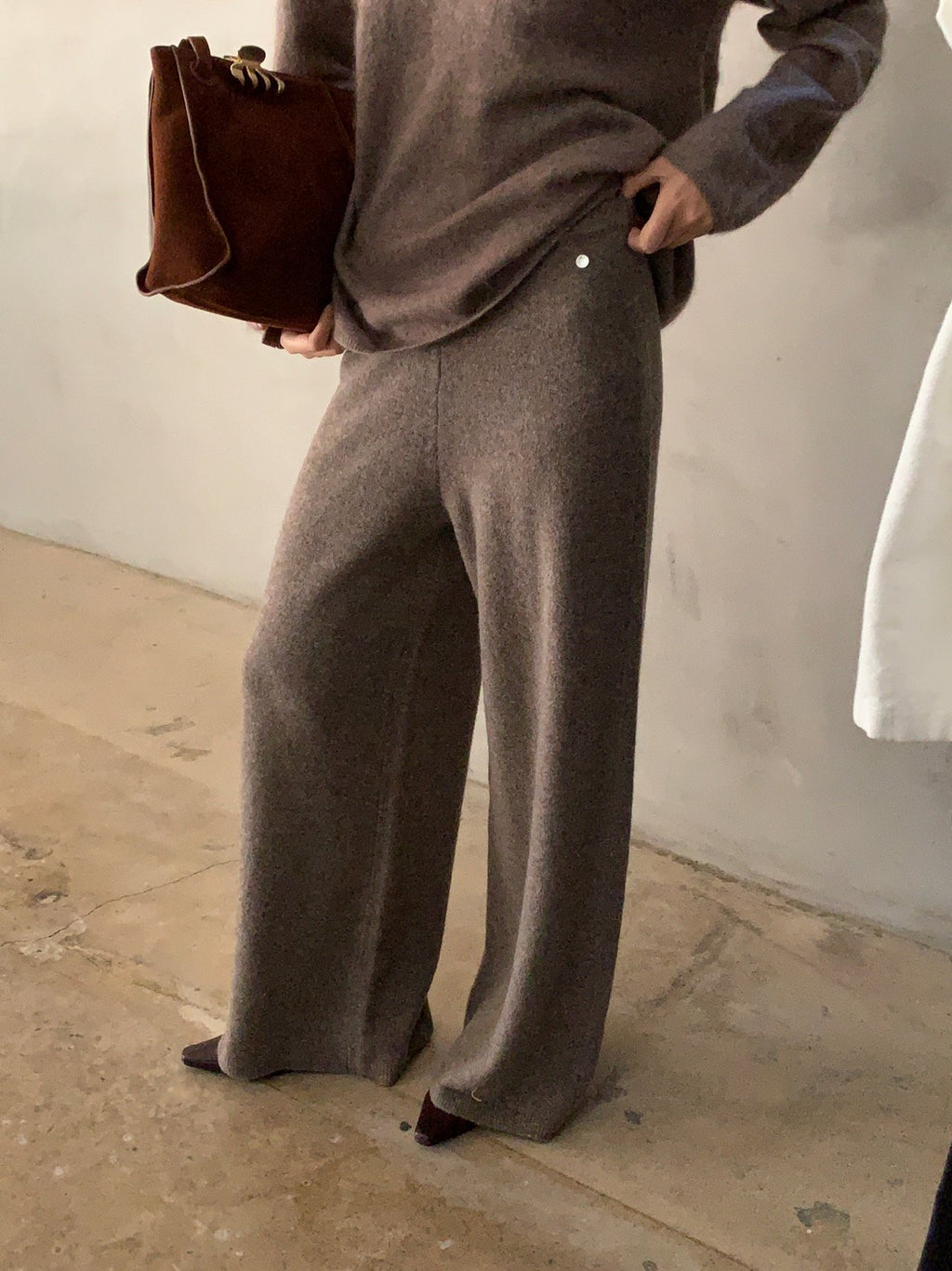 Front view of brown wide-leg knit pants worn with a brown V-neck sweater