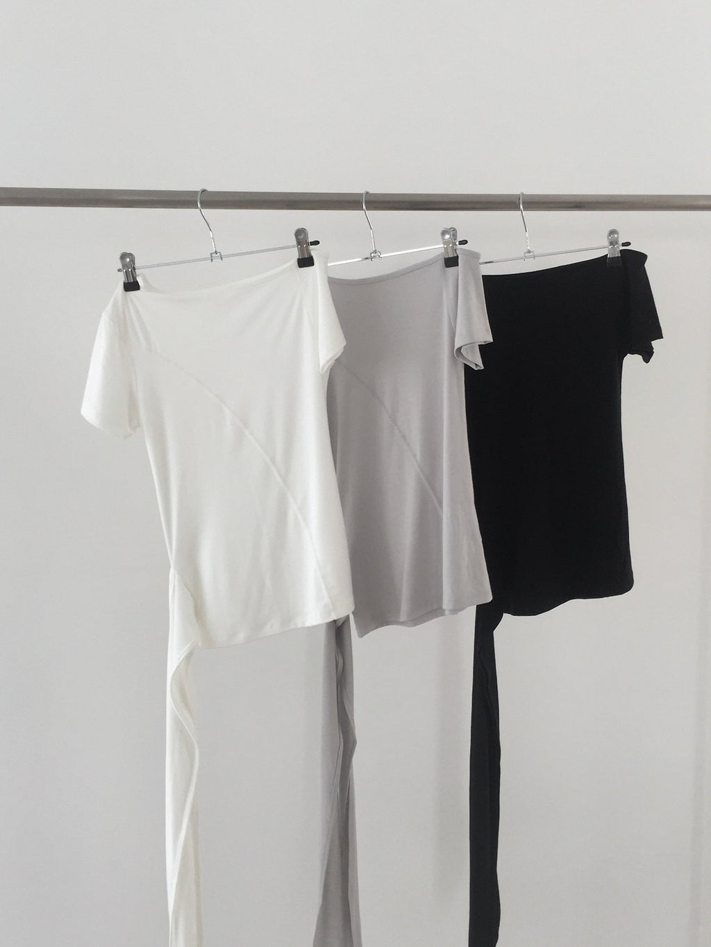 Nweol off-shoulder crop top with tie waist in Ivory, Light Grey and Black, three colorways on rack front view