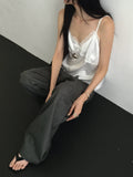 Nweol lace trim satin tank top in Ivory, styled on model seated front view with grey wide leg trousers