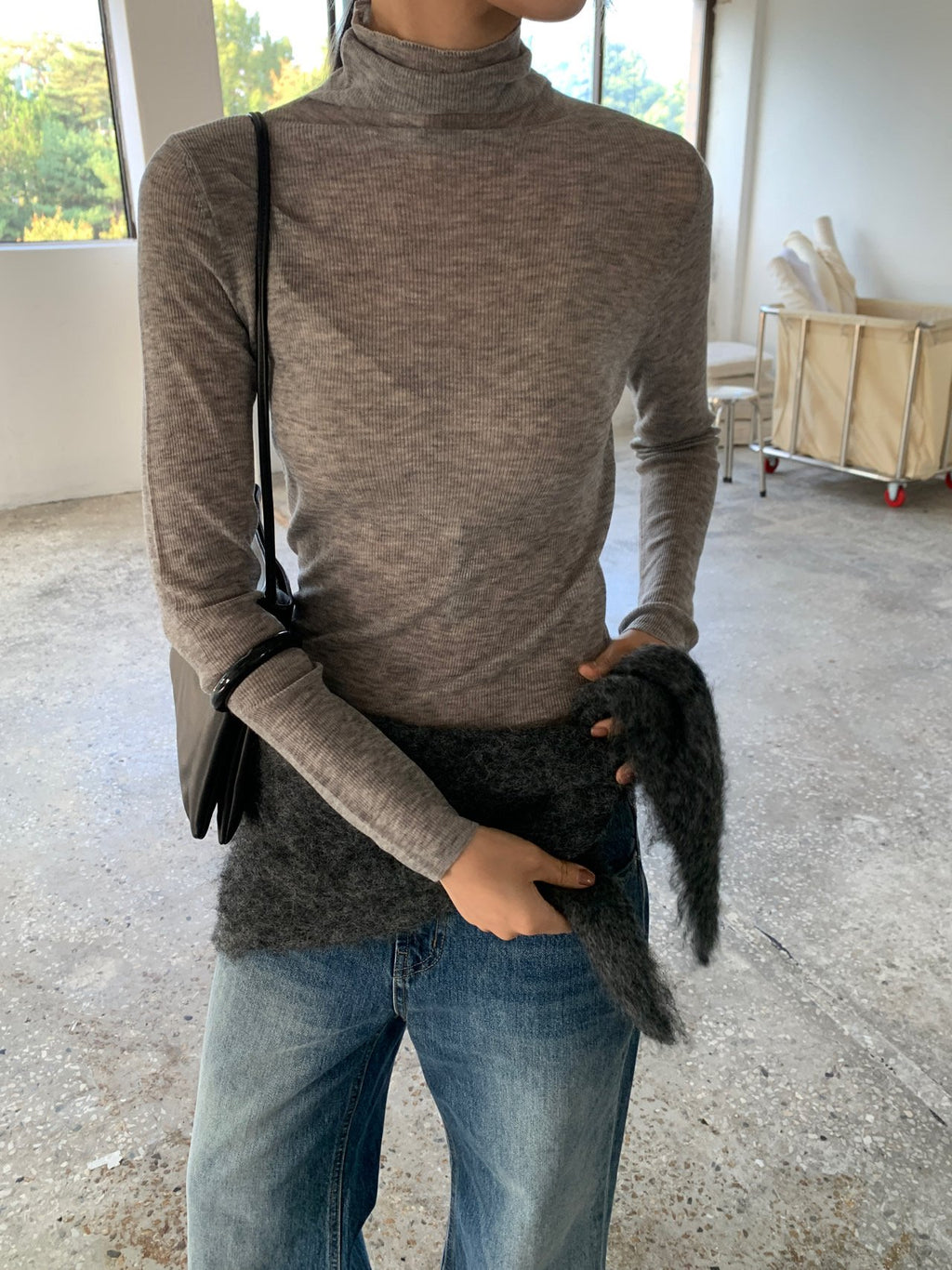 Grey long-sleeve wool turtleneck sweater worn with jeans