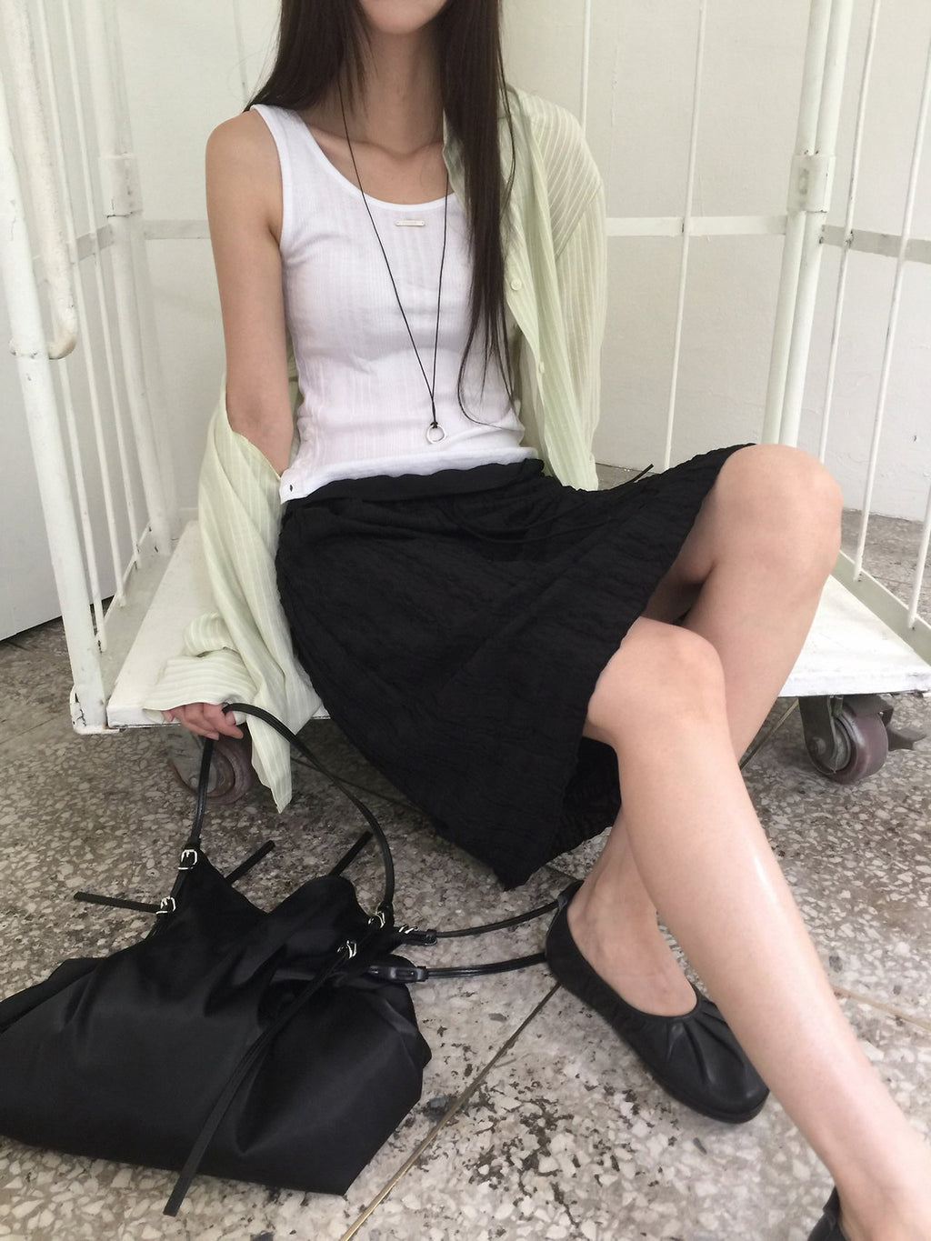 Nweol bubble texture midi skirt in Black, styled on model front view with white tank top and light green cardigan