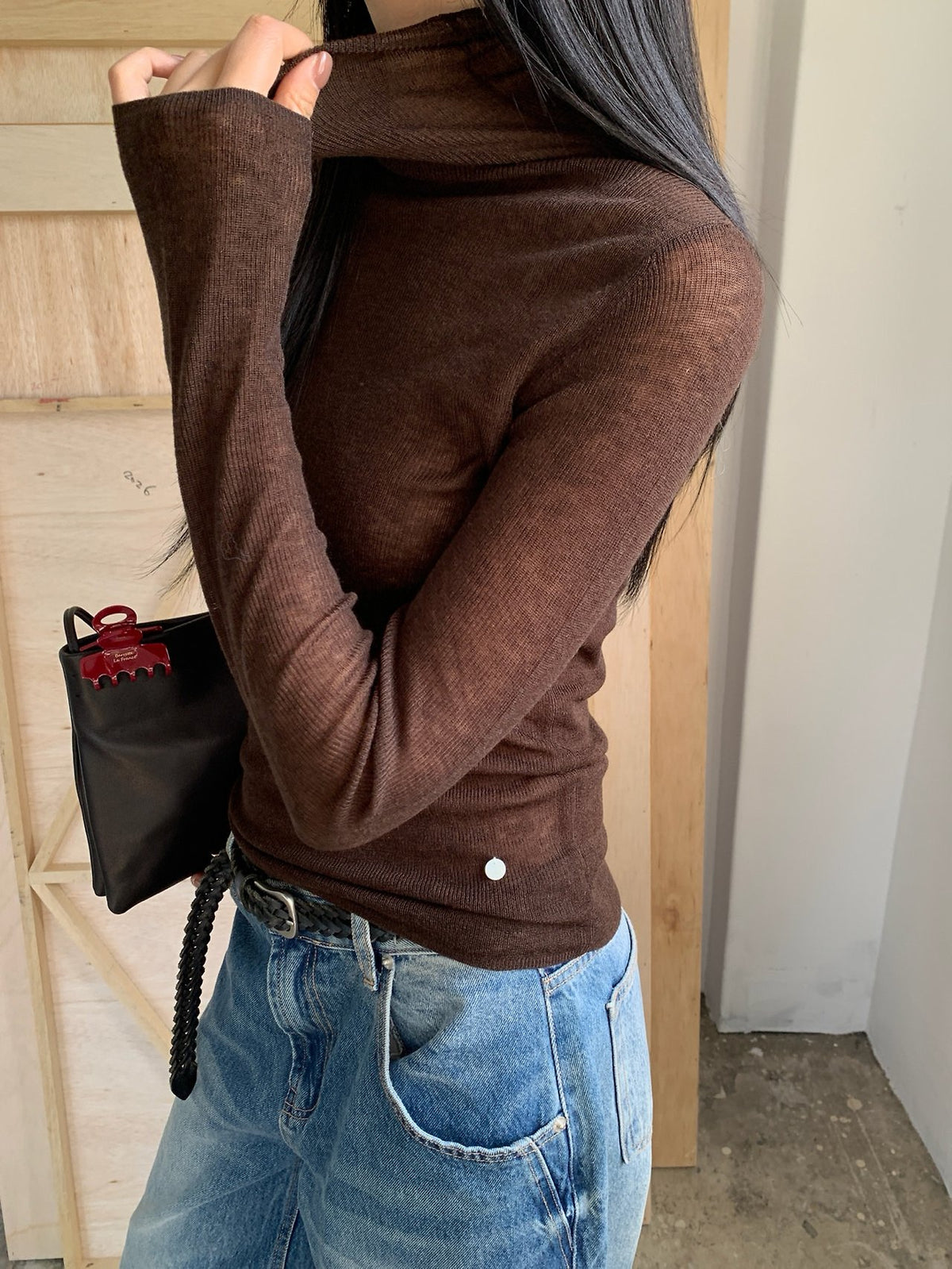 Grey turtleneck sweater layered under a black jacket