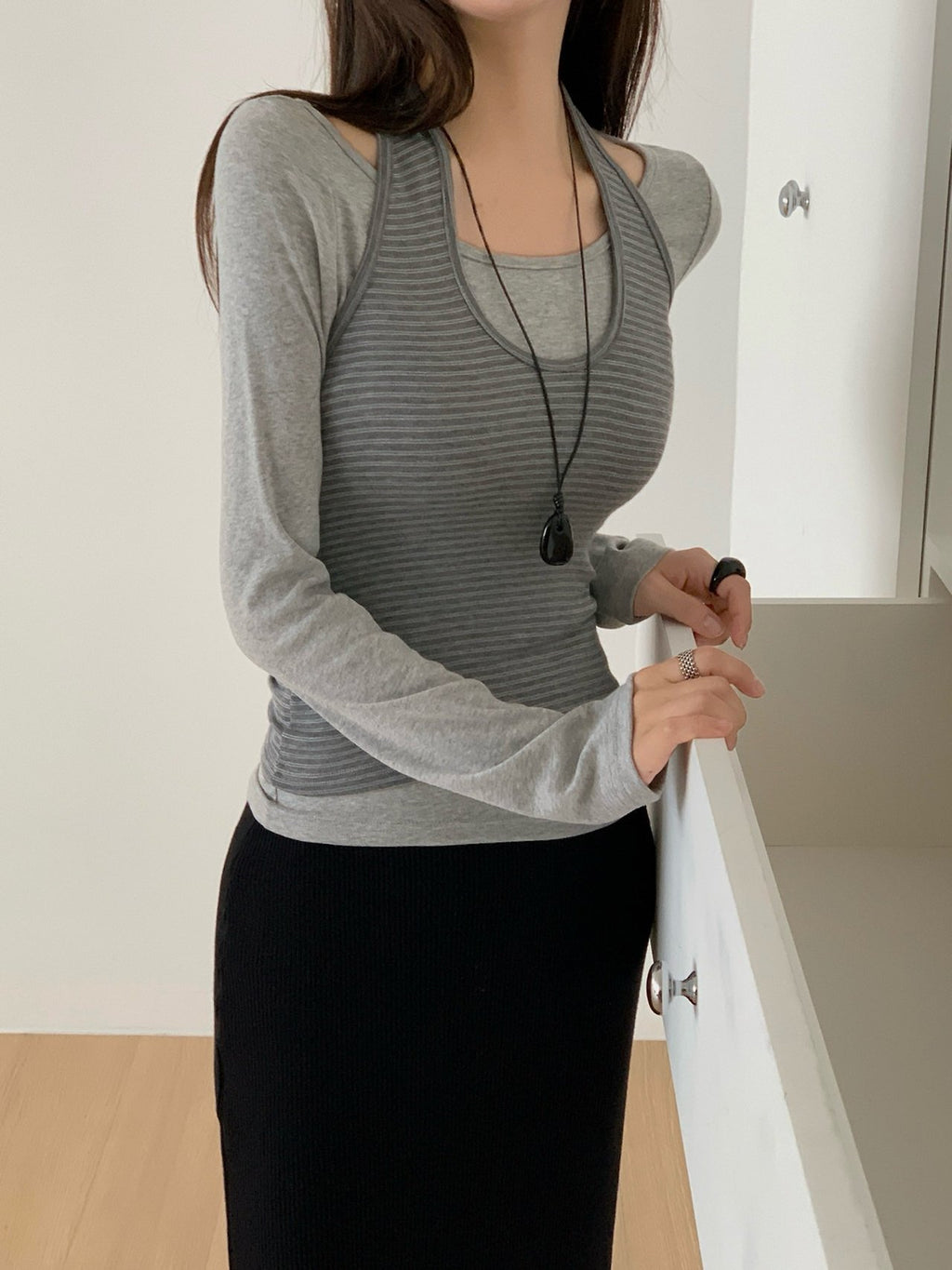Brown long-sleeve top layered with a striped tank top